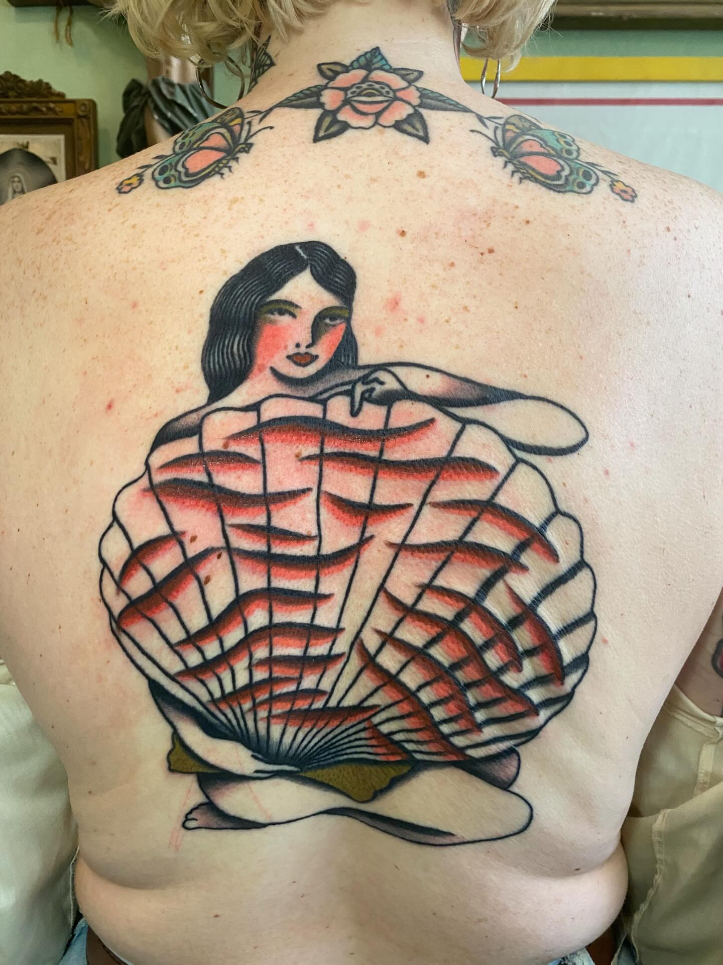 Woman in shell American traditional tattoo on the back by Jaclin Grace Hastings