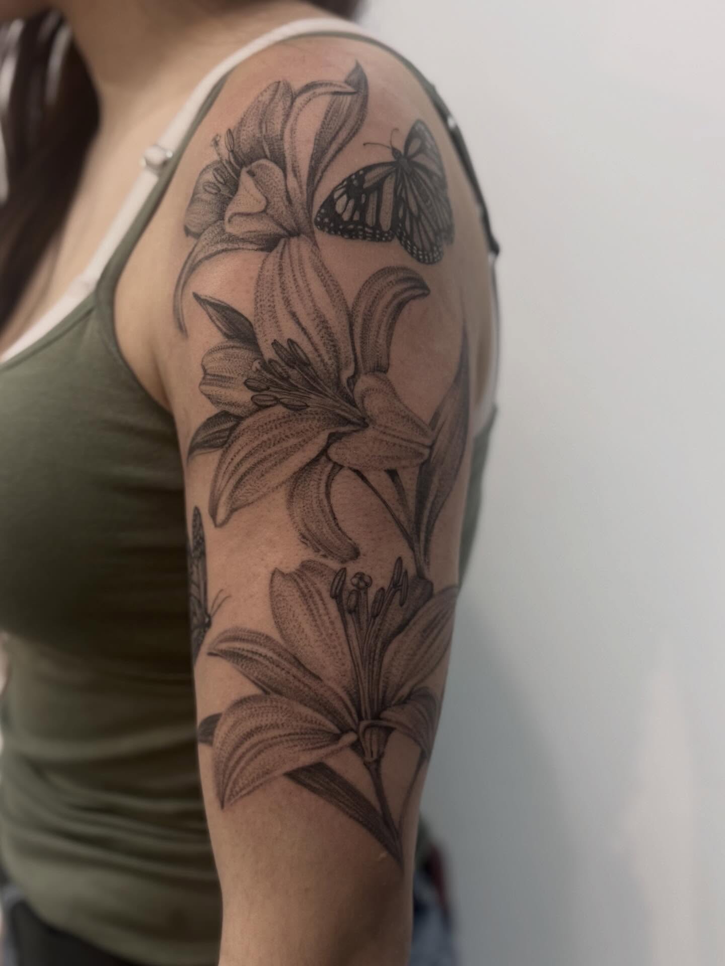 Lilies and butterfly realism tattoo on the forearm by Tianna Osborne