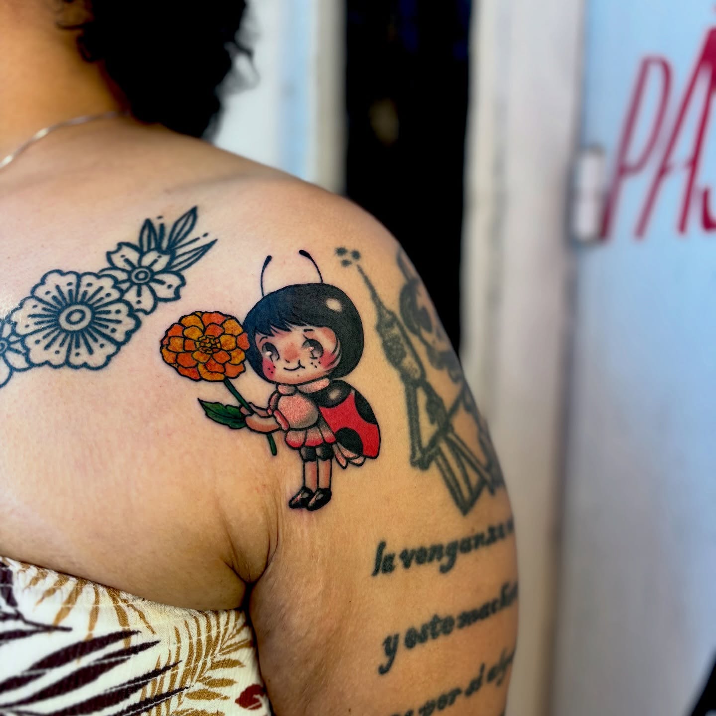 Ladybug and flower anime tattoo on the shoulder by Barbara Gonzalez