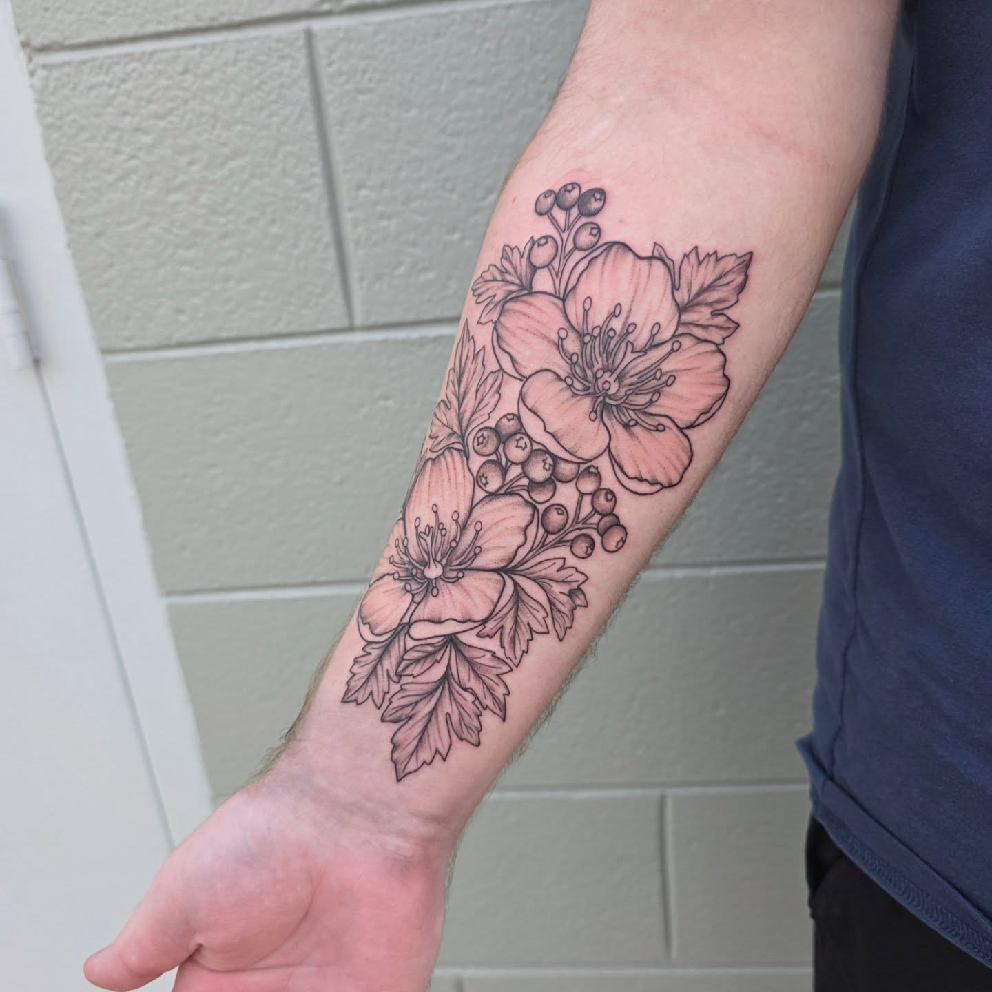 Floral arrangement black and grey tattoo on the forearm by Maggie