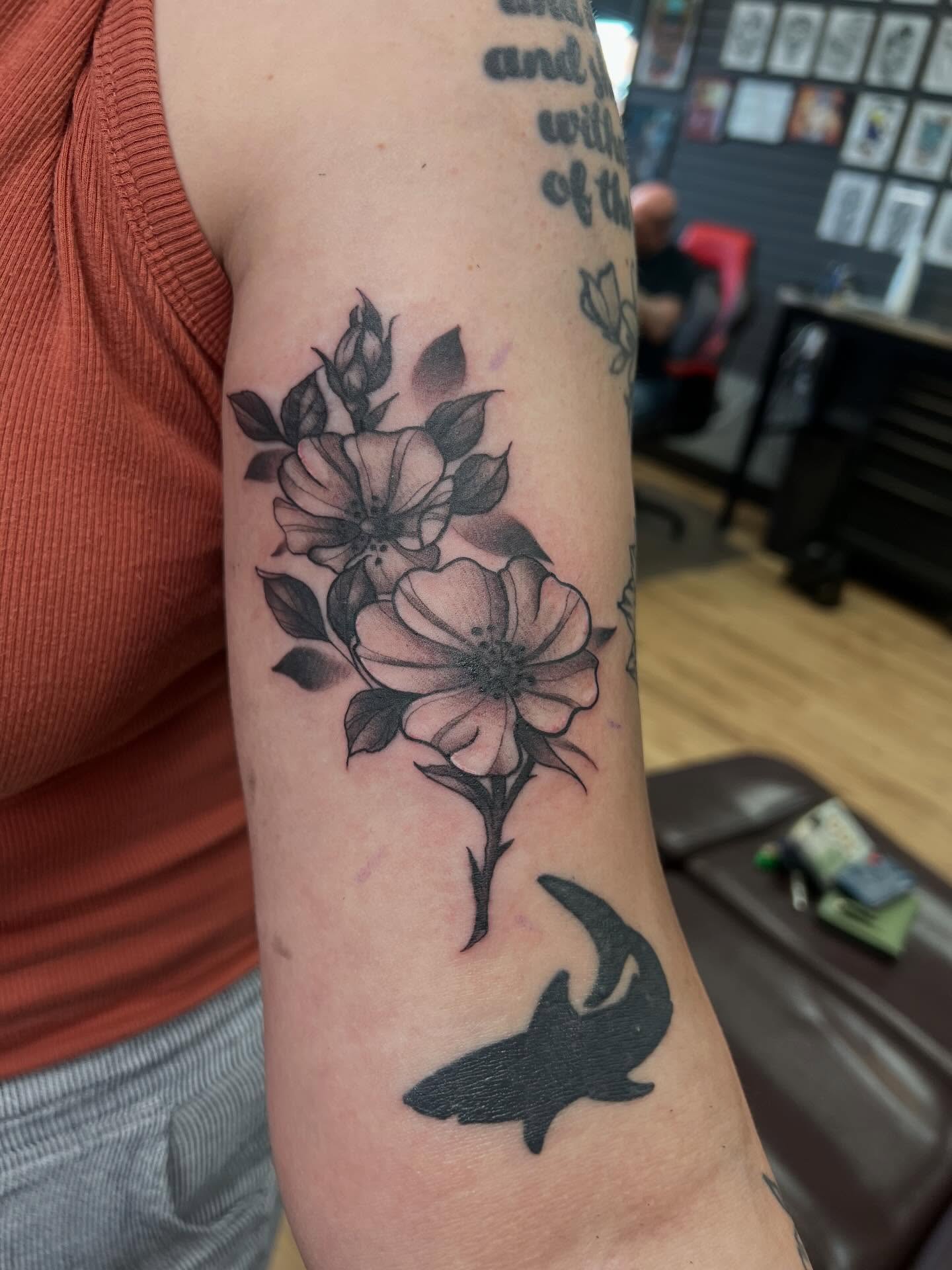 Flowers and shark black and grey tattoo on the forearm by Bailey Goodwin, Ankeny, Iowa
