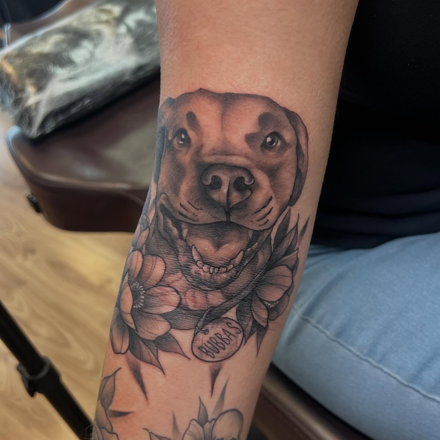 Dog with flowers realism tattoo on the forearm by Bailey Goodwin, Ankeny, Iowa