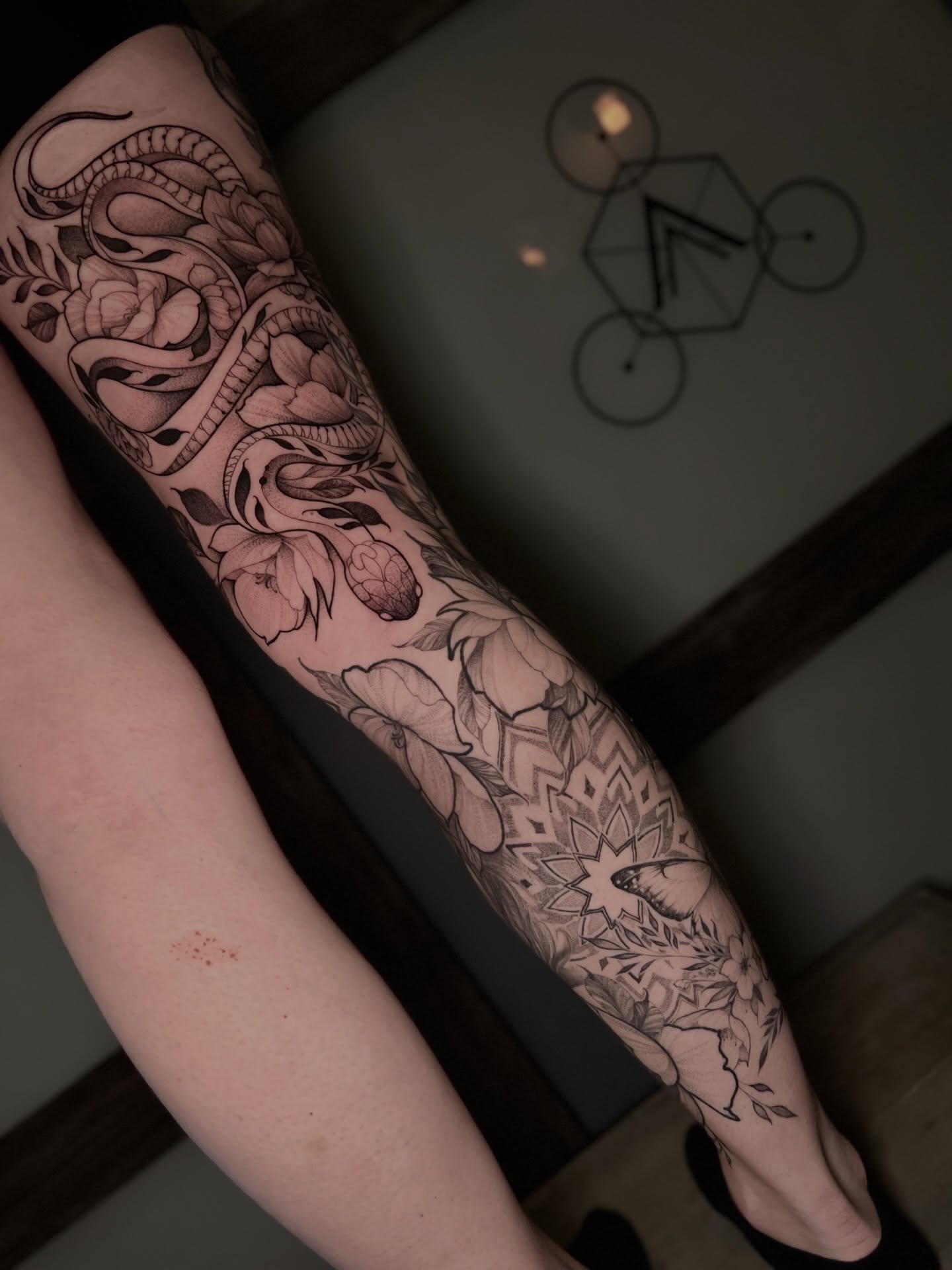 Snake and floral geometric tattoo on the forearm by Dominick Cali, East Islip, New York