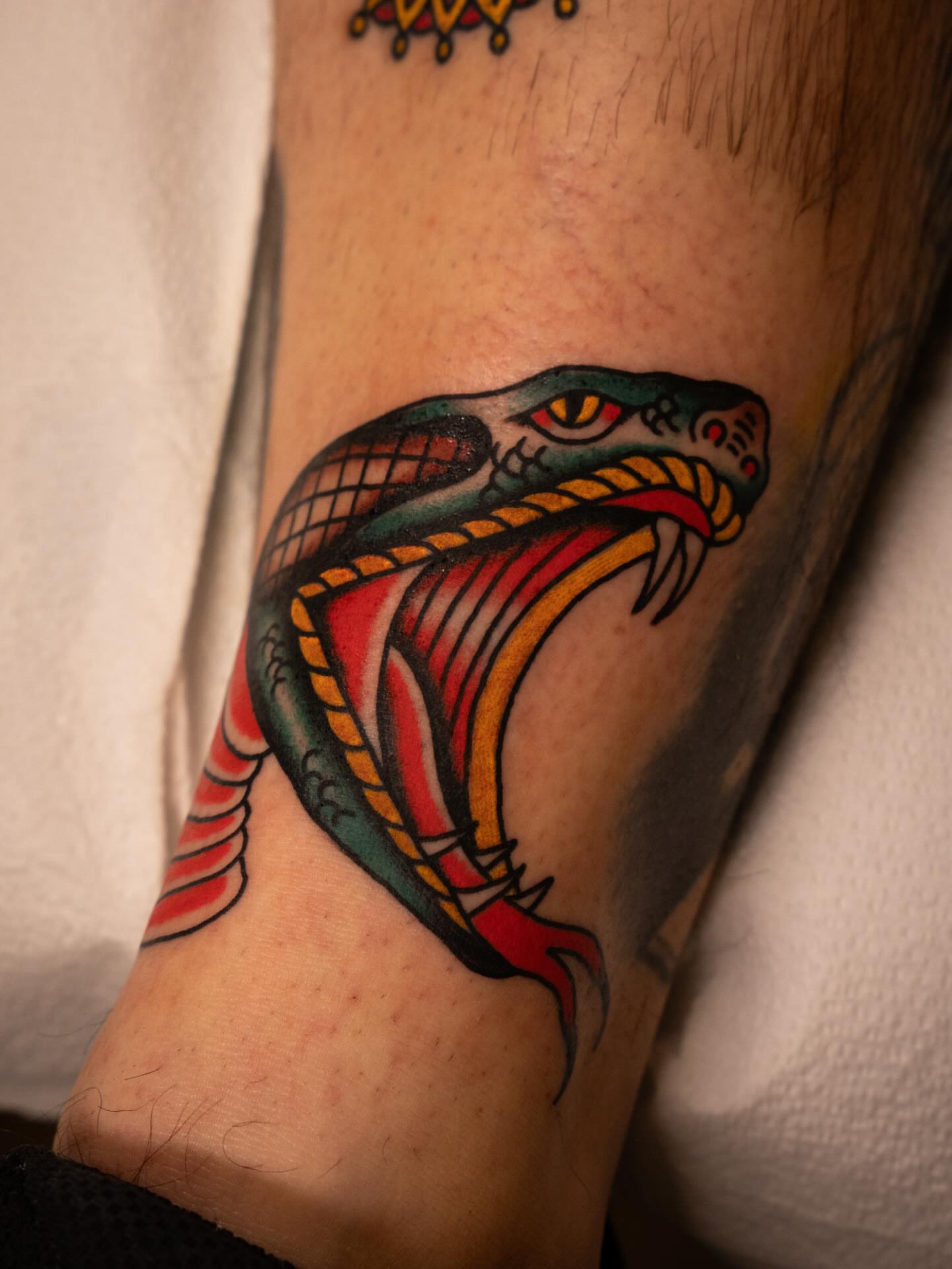 Snake American traditional tattoo on the forearm by Justin Rakowski
