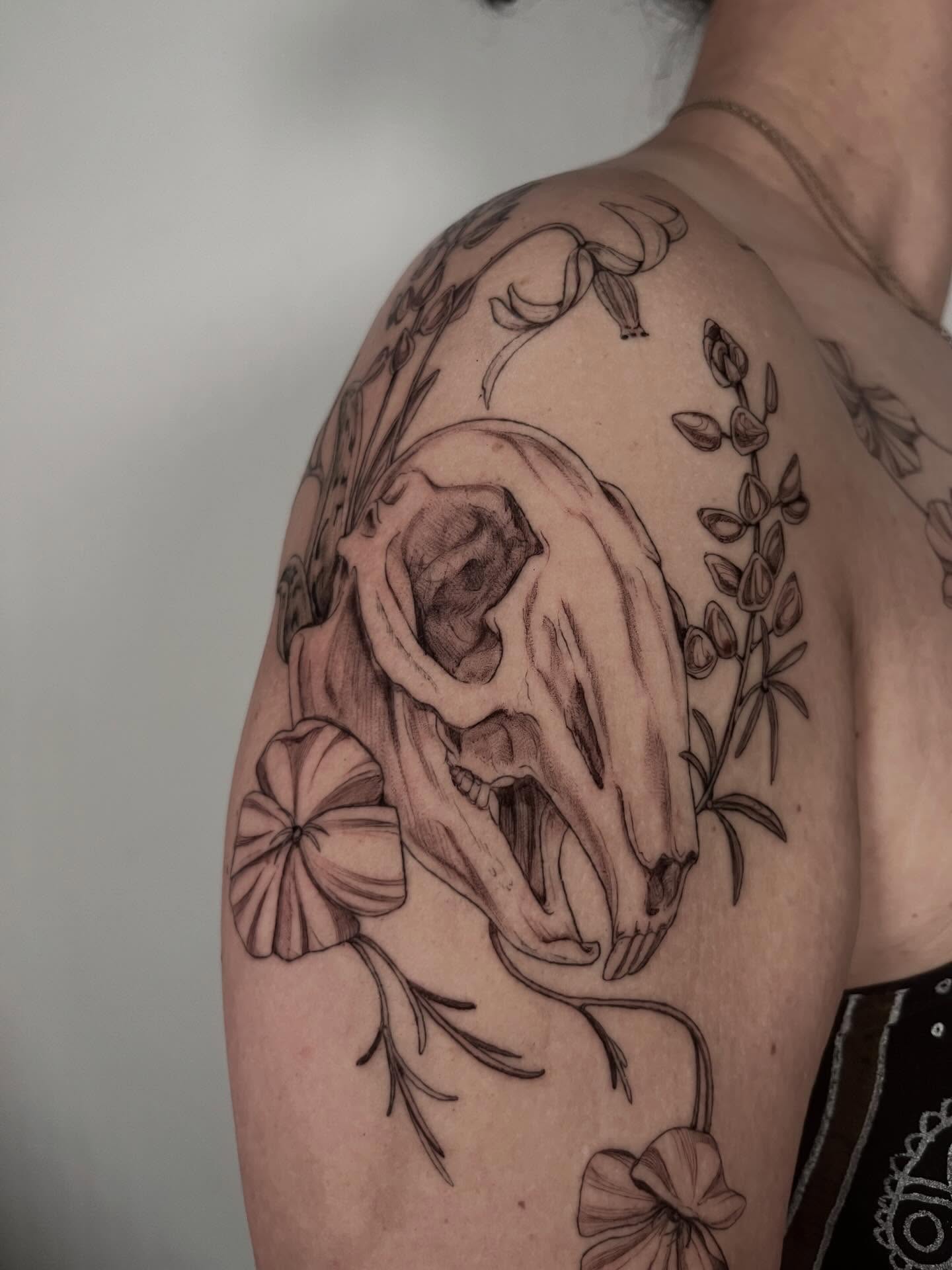 Skull and floral realism tattoo on the shoulder by Sierra Skye