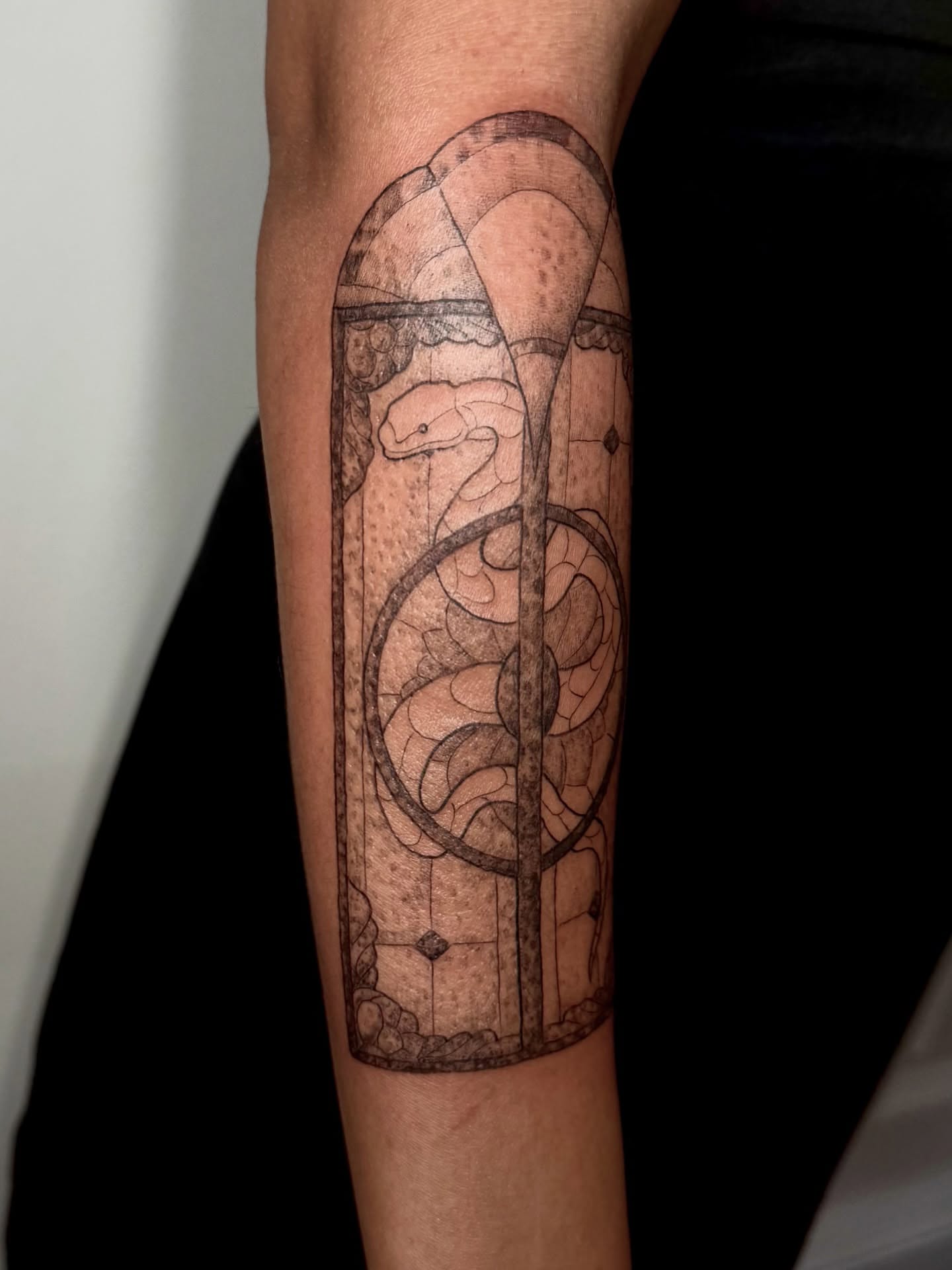 Snake geometric tattoo on the forearm by Ian Saner