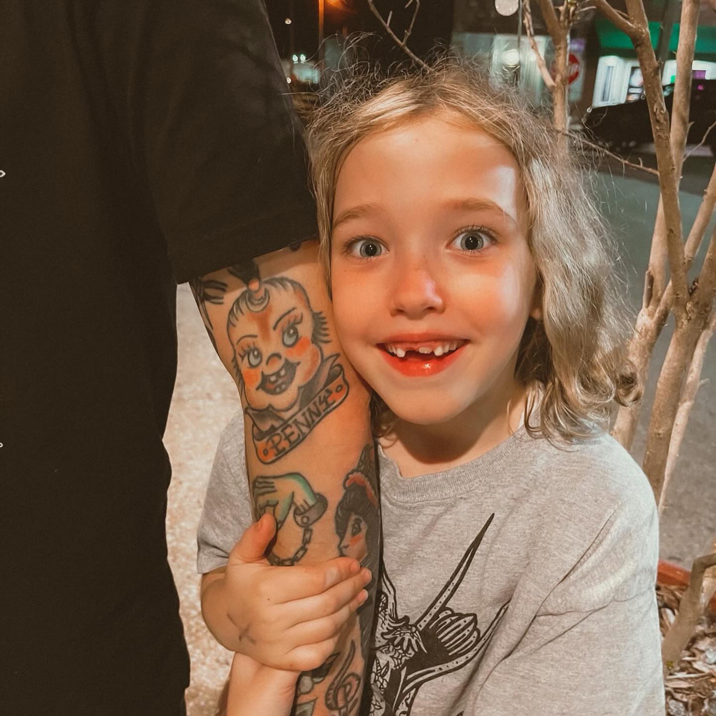 Child American traditional tattoo on the upper arm by Jacob, Marion, Illinois