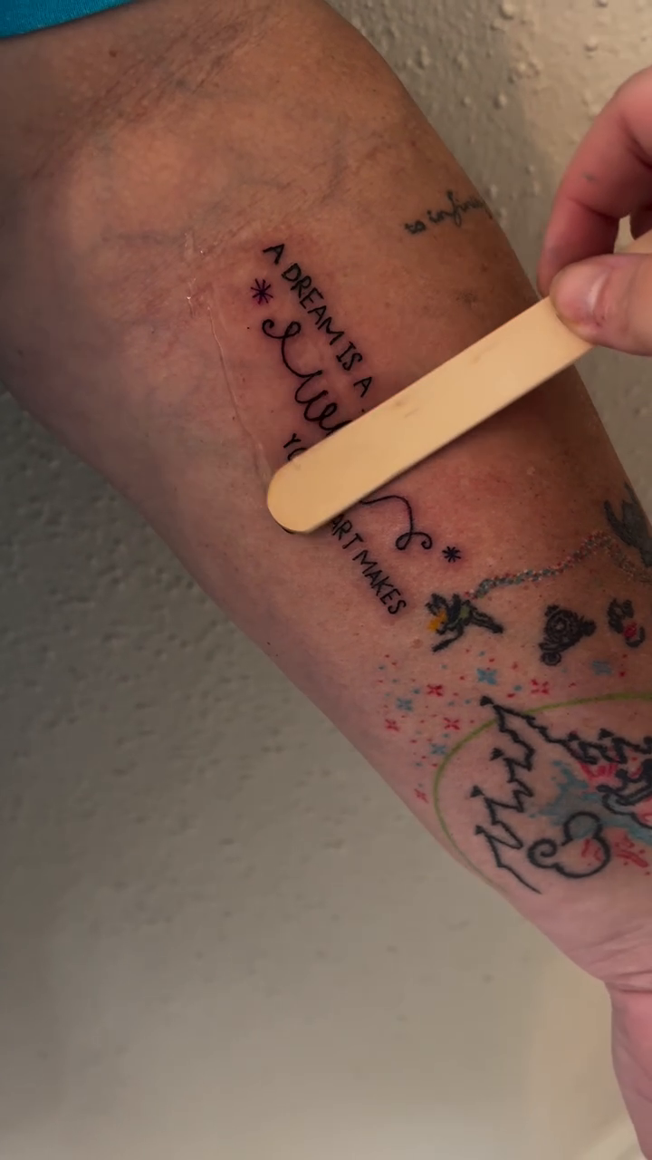 Script tattoo with floral elements lettering tattoo on the forearm by Victoria Cooper