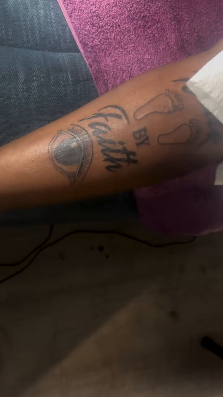 Tattoo with footprints and text lettering tattoo on the upper arm by TP