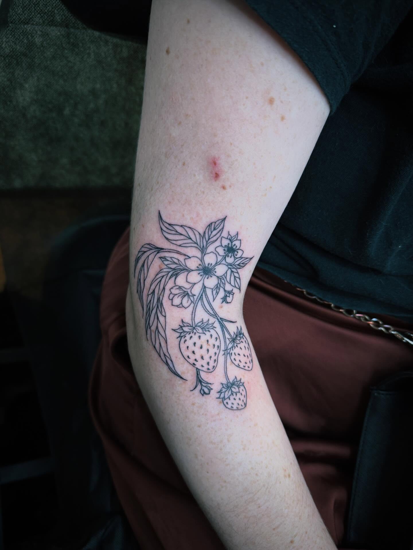 Strawberries and flowers black and grey tattoo on the forearm by Kraken ink Tattoo, San Francisco, California