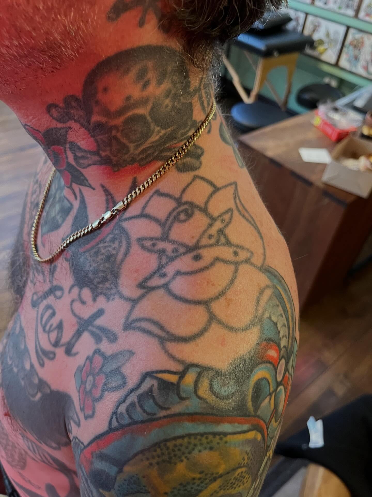 Lotus flower American traditional tattoo on the upper arm by Chris Kline