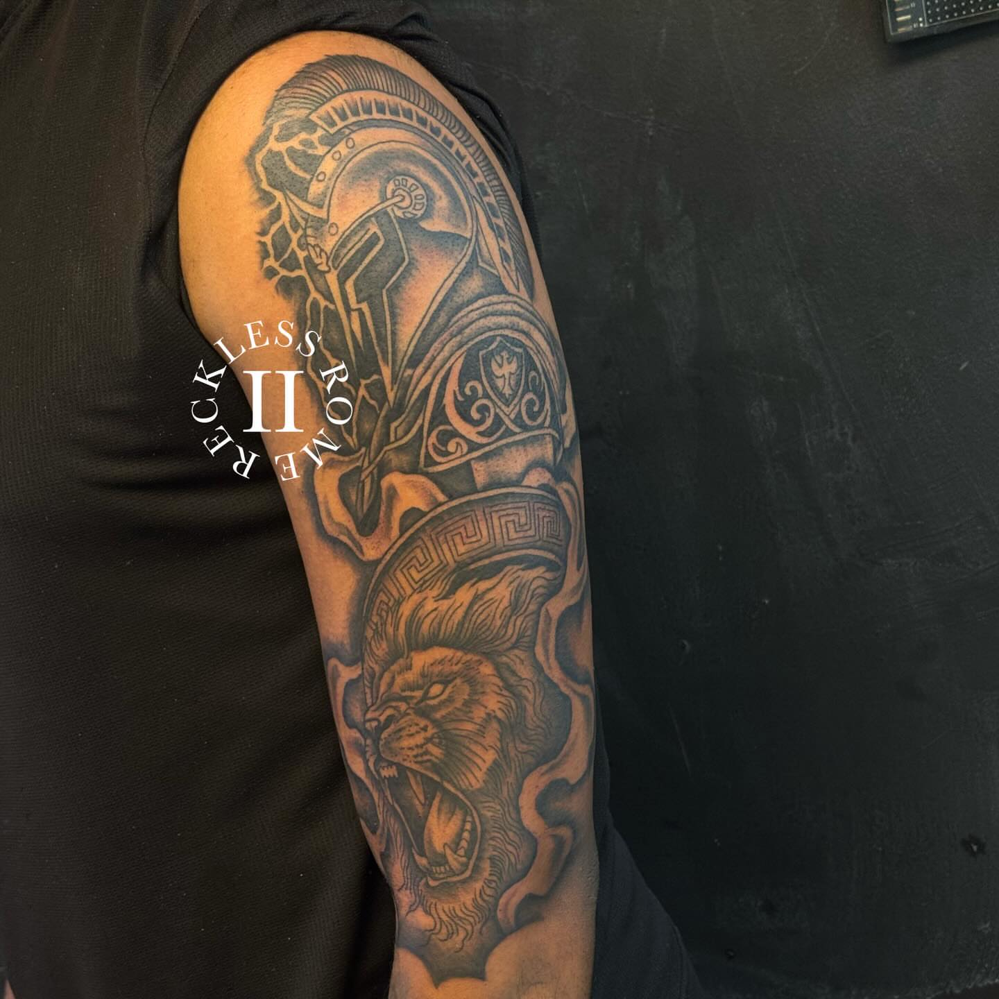 Lion and helmet realism tattoo on the forearm by Rome