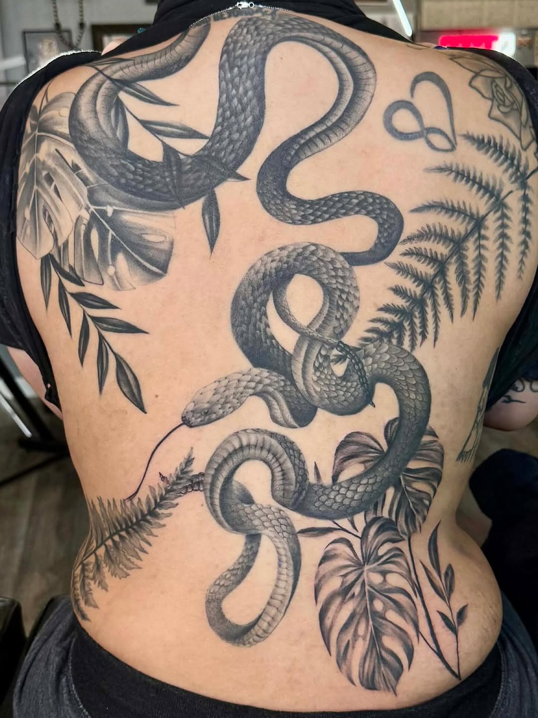 Snake and tropical leaves dotwork tattoo on the back by Stephanie Cruz, Kansas City, Missouri