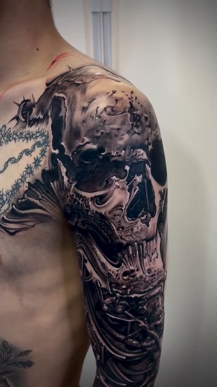 Skull and bones sleeve dark realism tattoo by Robert Hernandez