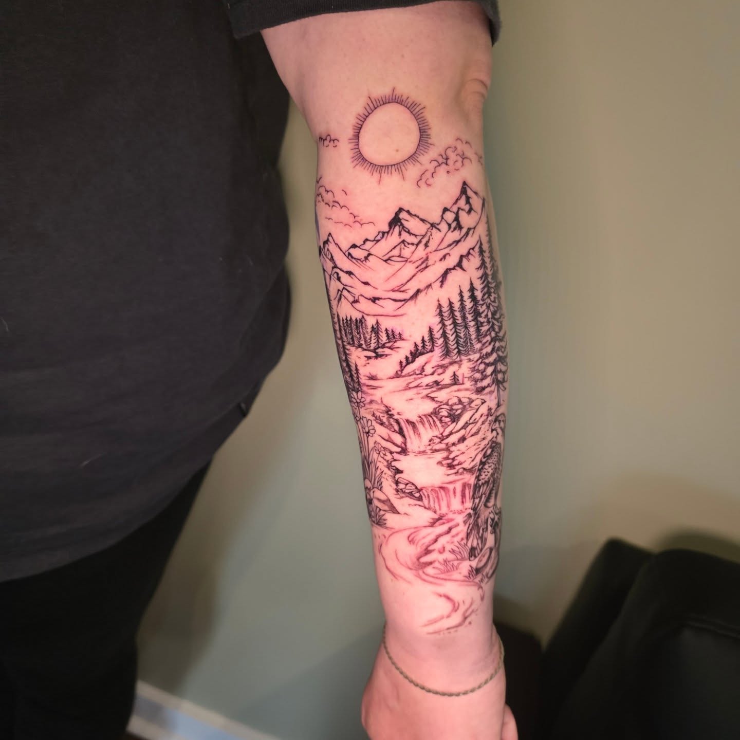 Mountain landscape realism tattoo on the forearm by Maggie