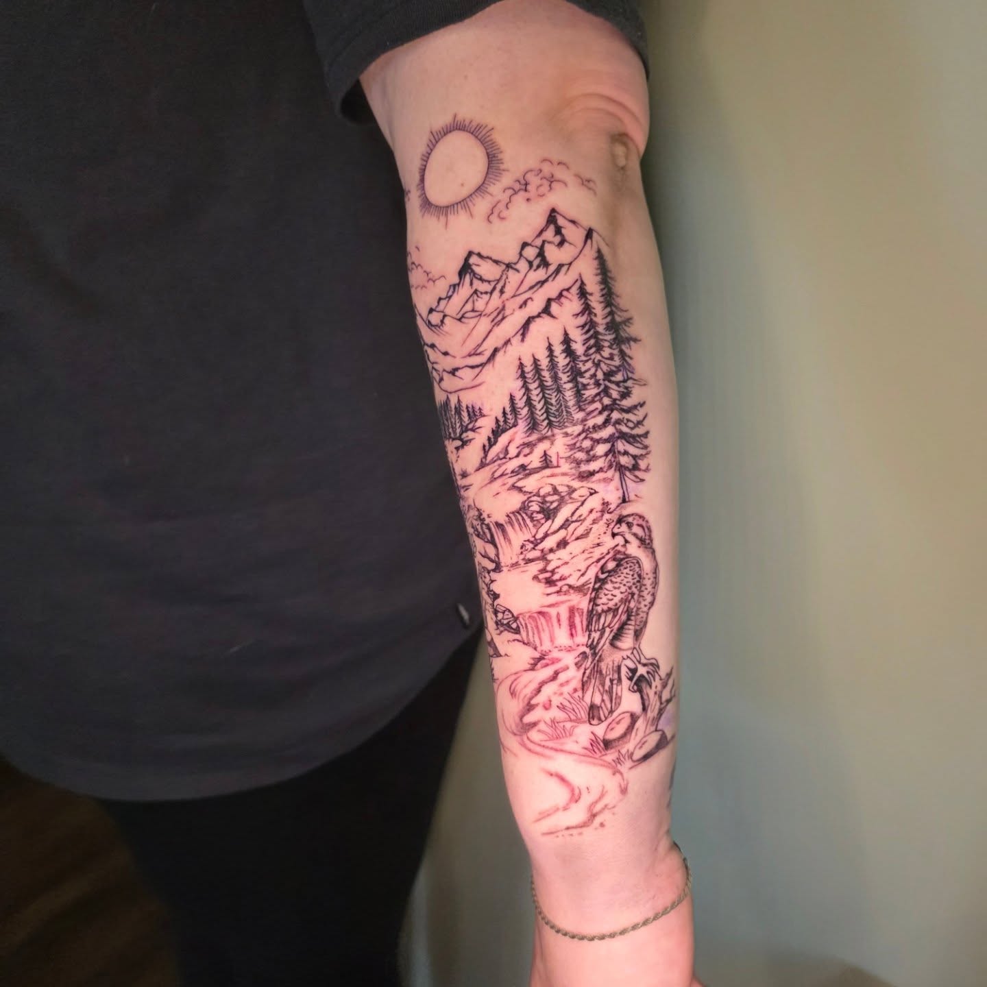 Mountain landscape realism tattoo on the forearm by Maggie