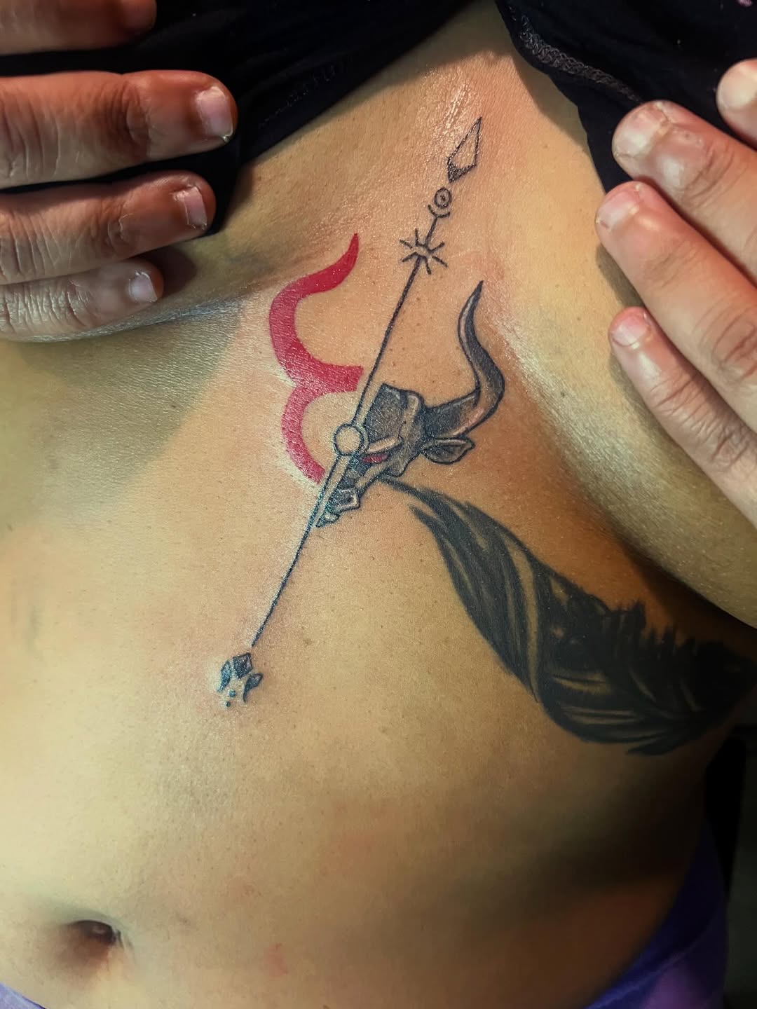 Bull head with trident and feather tattoo on the ribs by Deangelo Inkcrazy Dukes