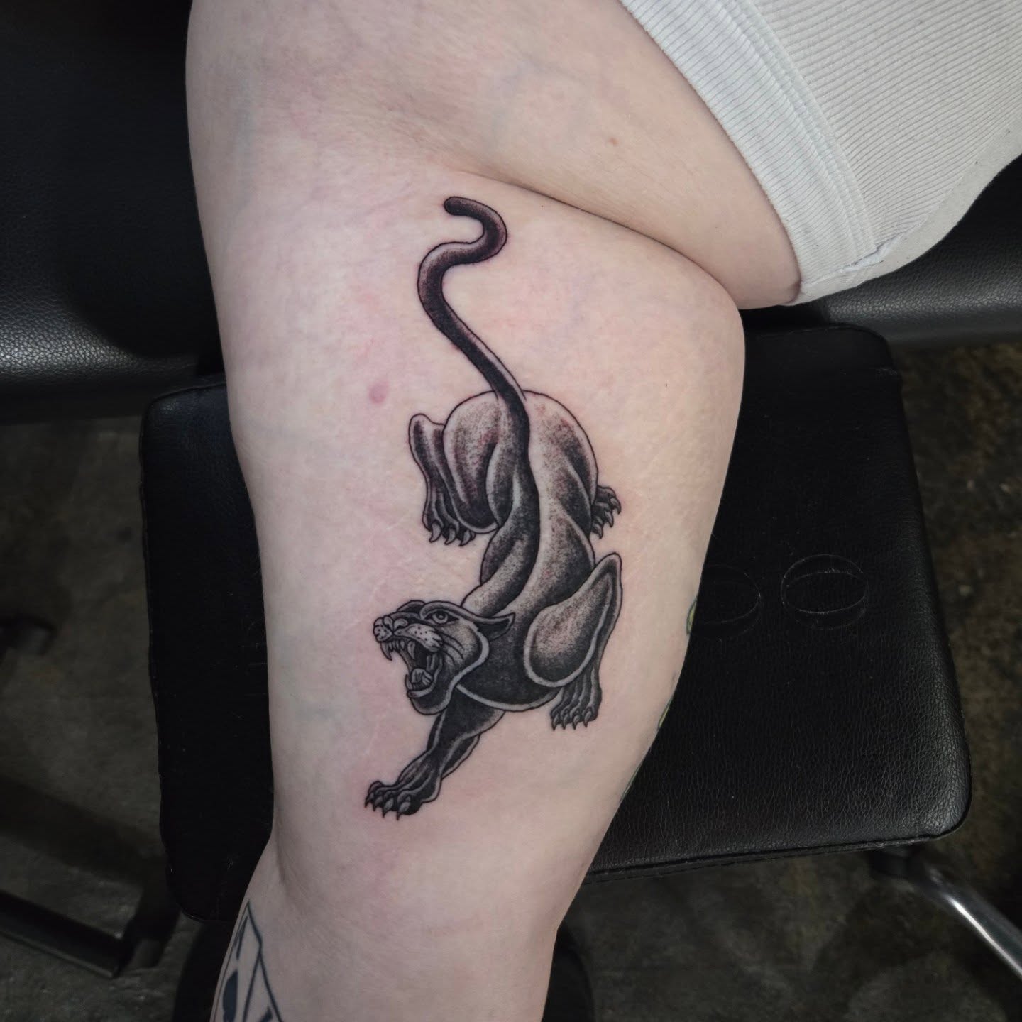 Panther black and grey tattoo on the thigh by Perry