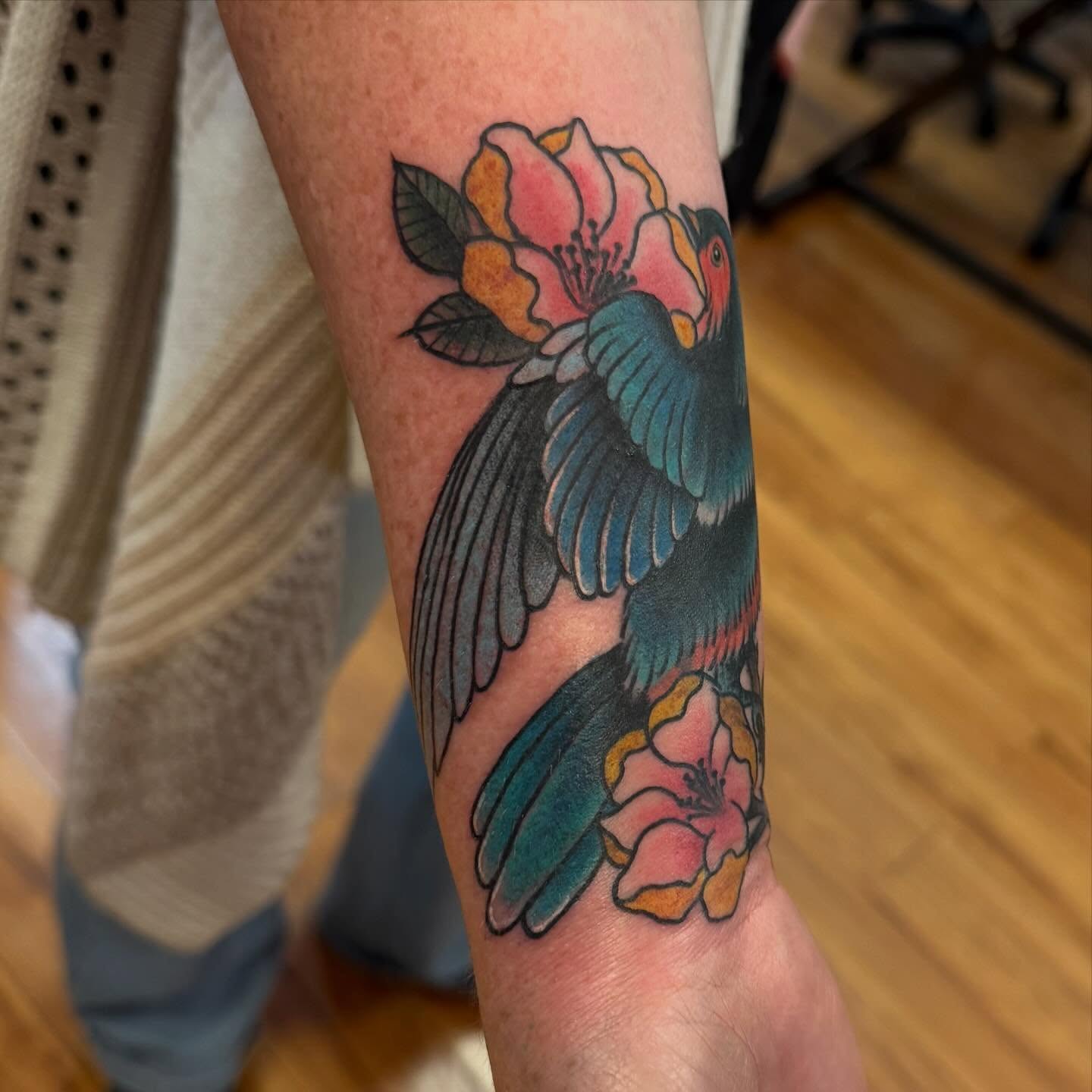 Bird and flowers American traditional tattoo on the forearm by Madilynn Klassen