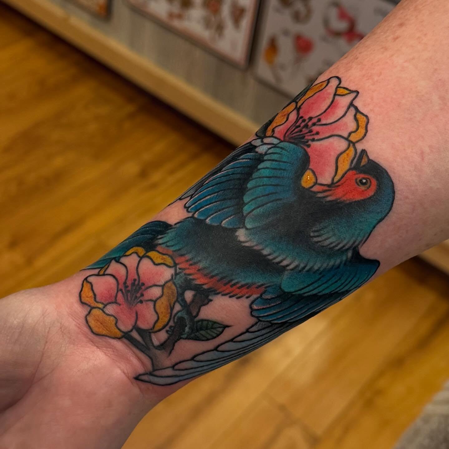 Bird and flowers American traditional tattoo on the forearm by Madilynn Klassen