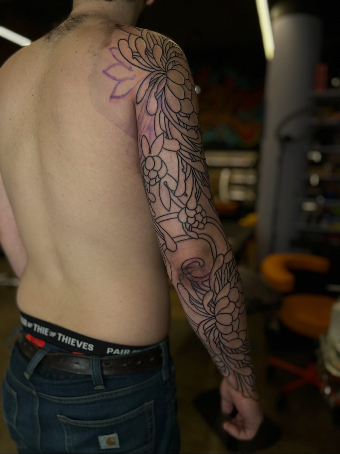Lotus flowers black and grey tattoo on the upper arm by Kaichi Fujita, Eugene, Oregon