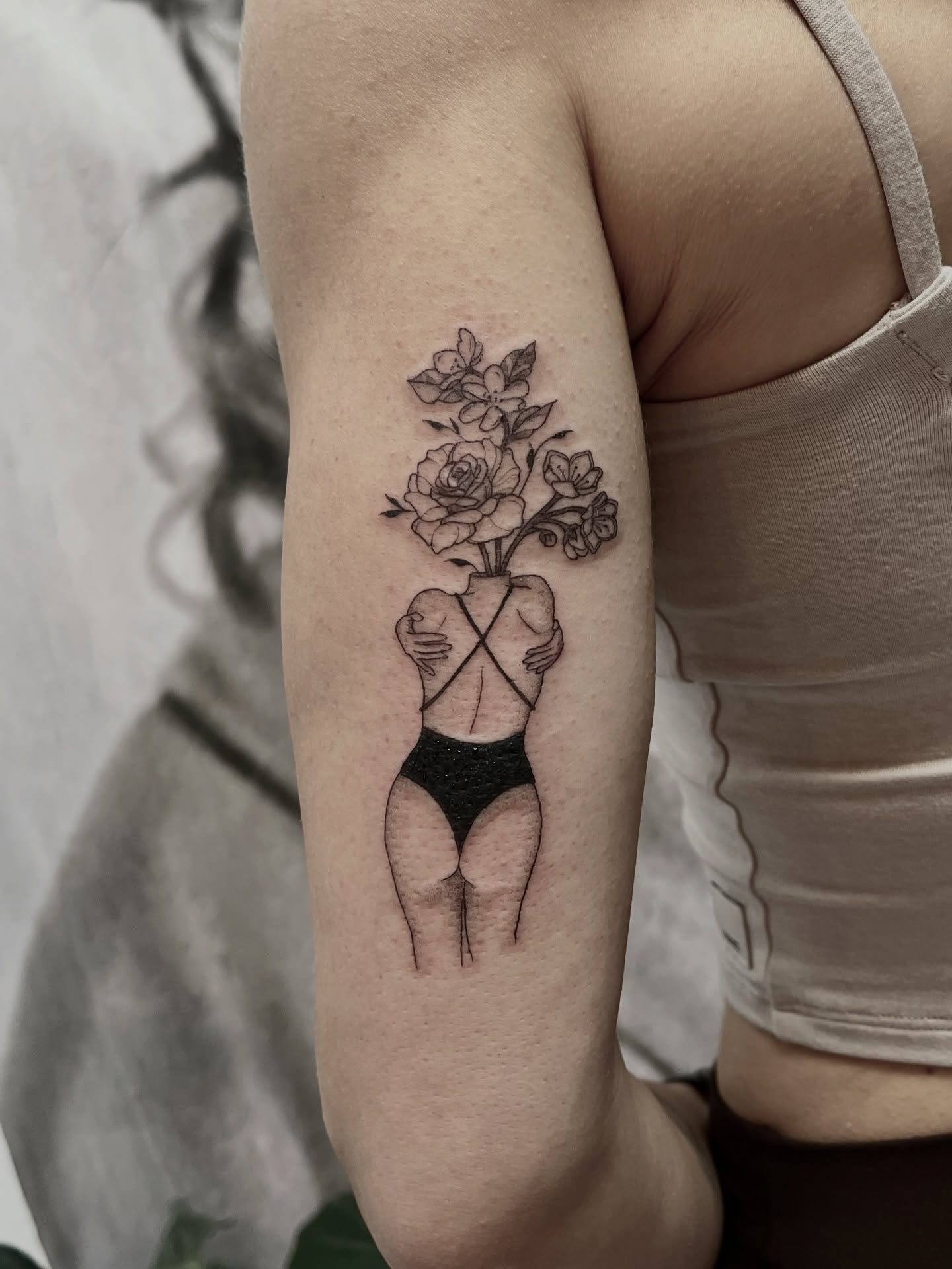 Woman with flowers black and grey tattoo on the forearm by Lo Gwynn
