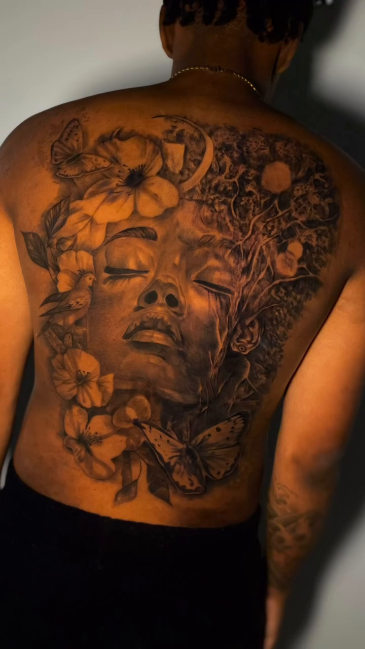 Woman's face with flowers and butterflies realism tattoo by Tattoo Artist