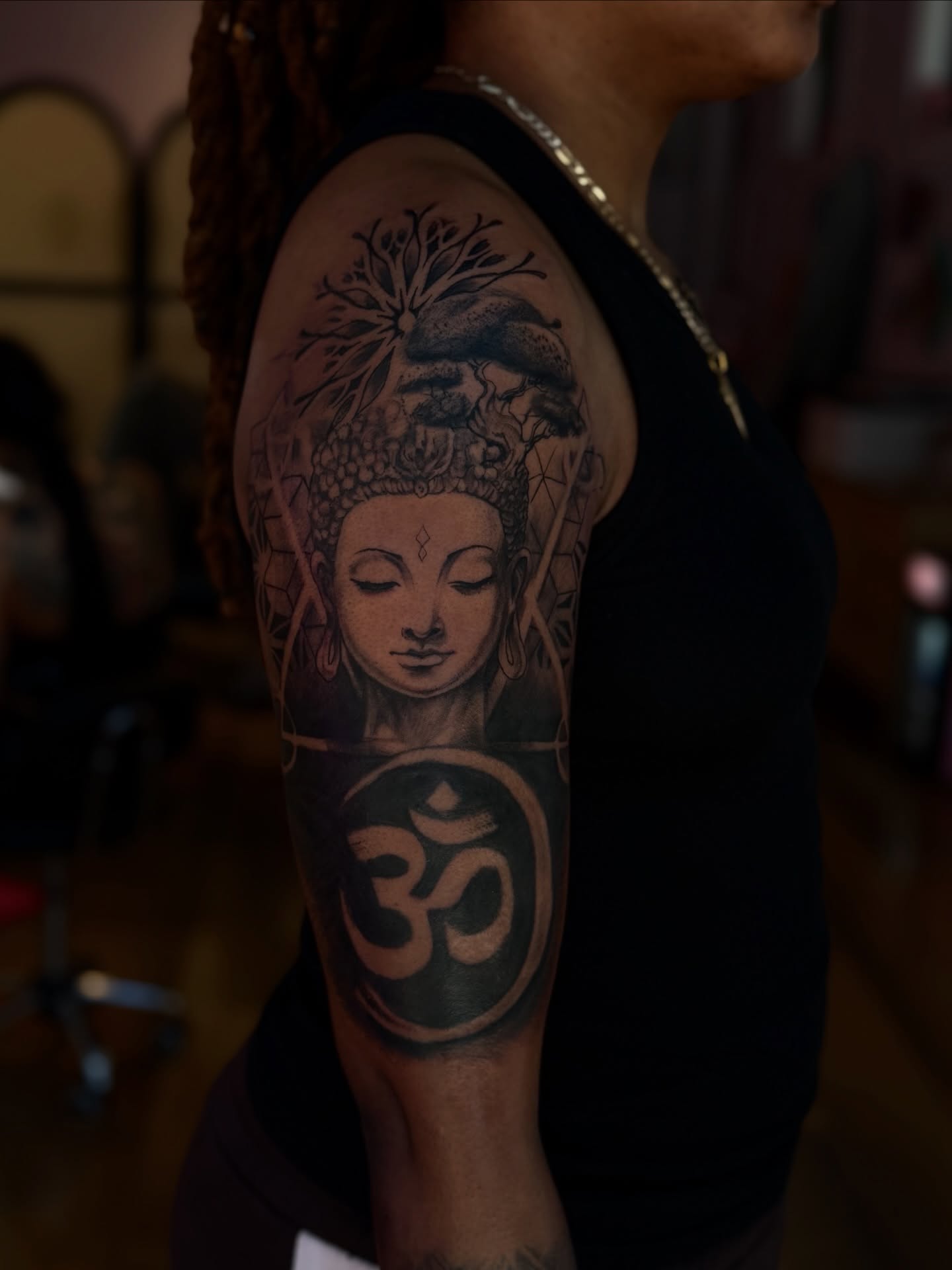Buddha head with om symbol geometric tattoo on the upper arm by Asia Rene Tattoos👑