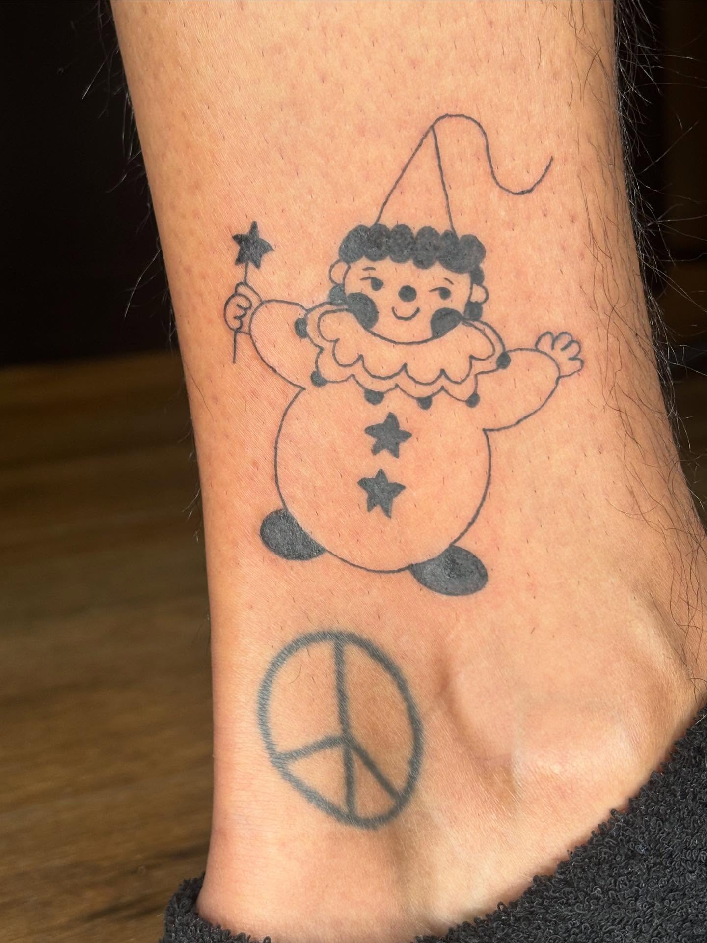 Clown with magic wand black and grey tattoo on the foot by riley