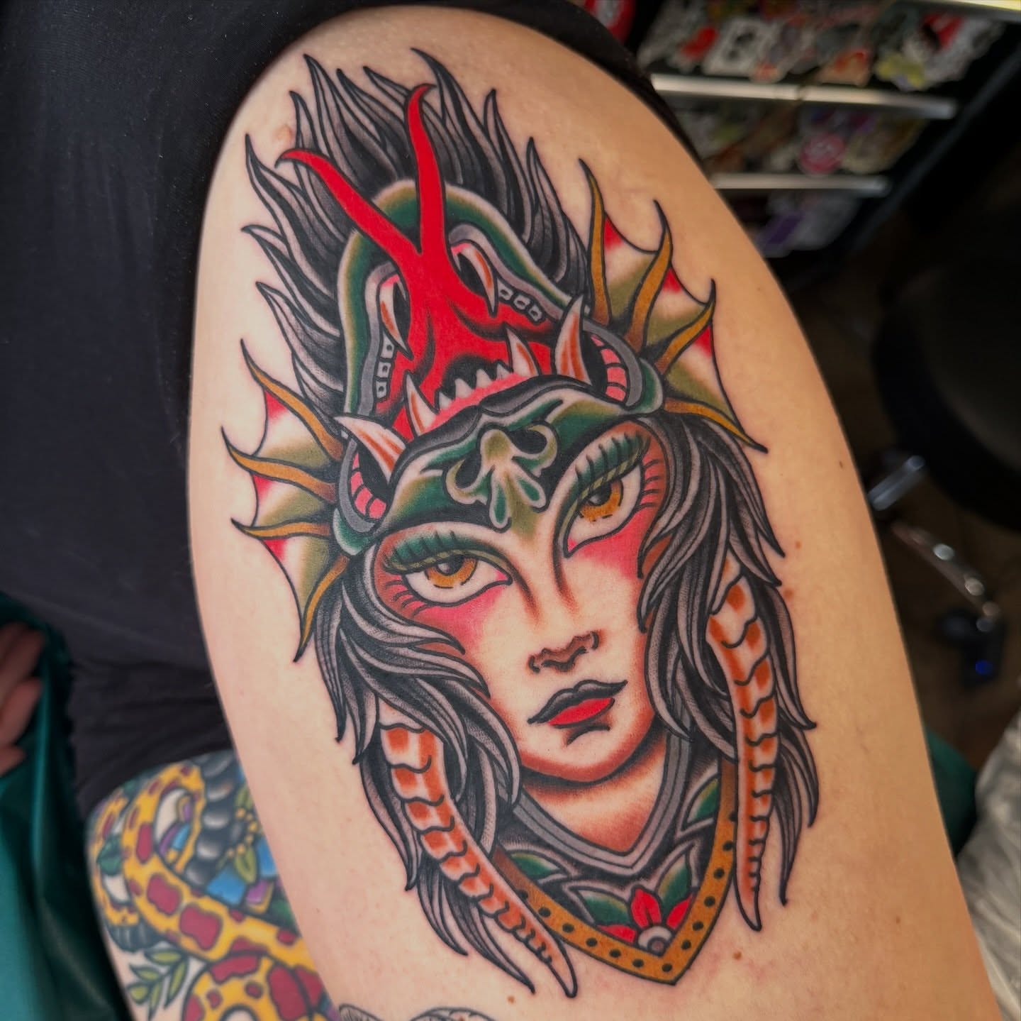 Woman with dragon headdress American traditional tattoo on the shoulder by Christopher Mikesell