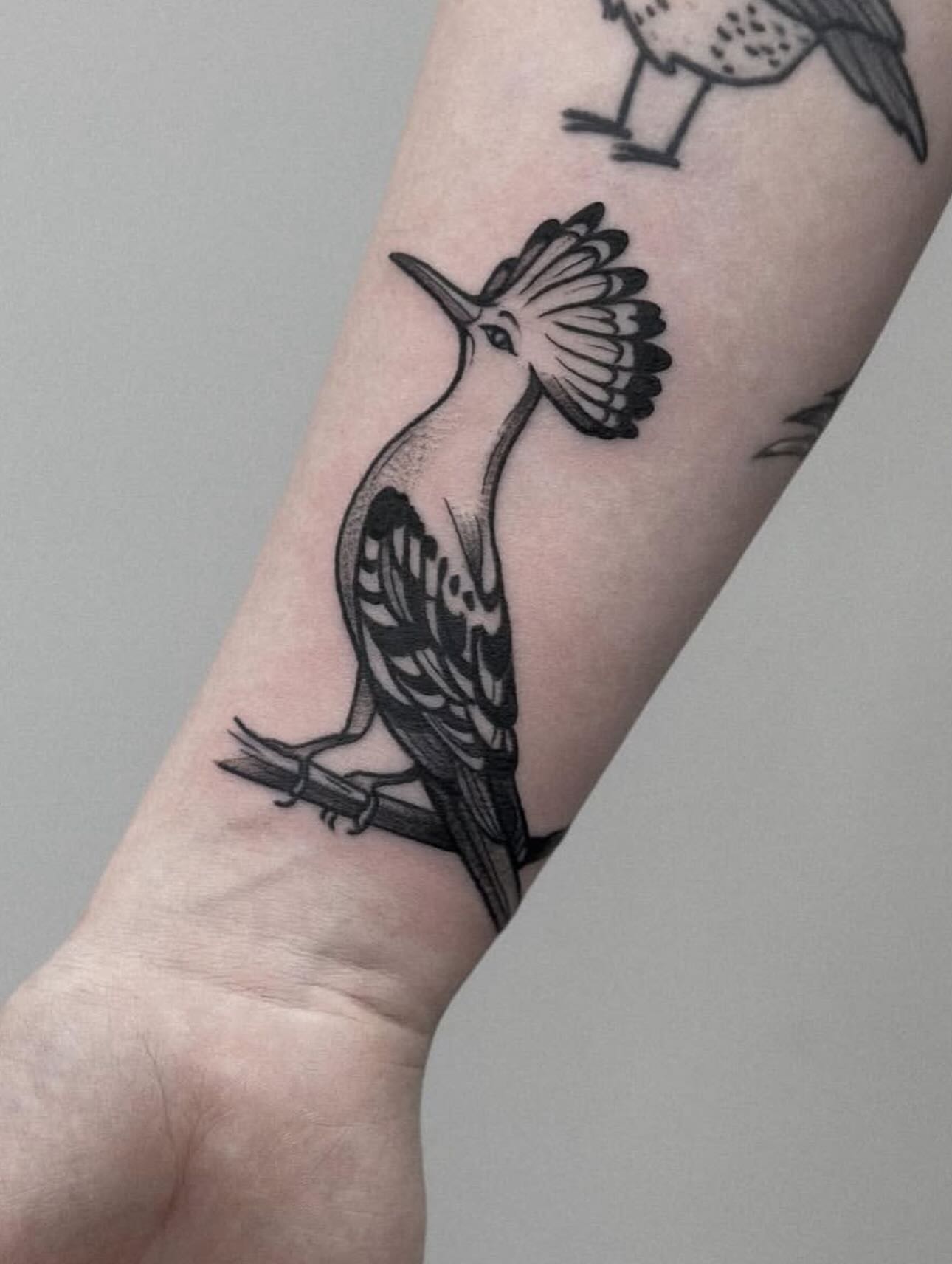 Bird black and grey tattoo on the forearm by Elvira Savchuk