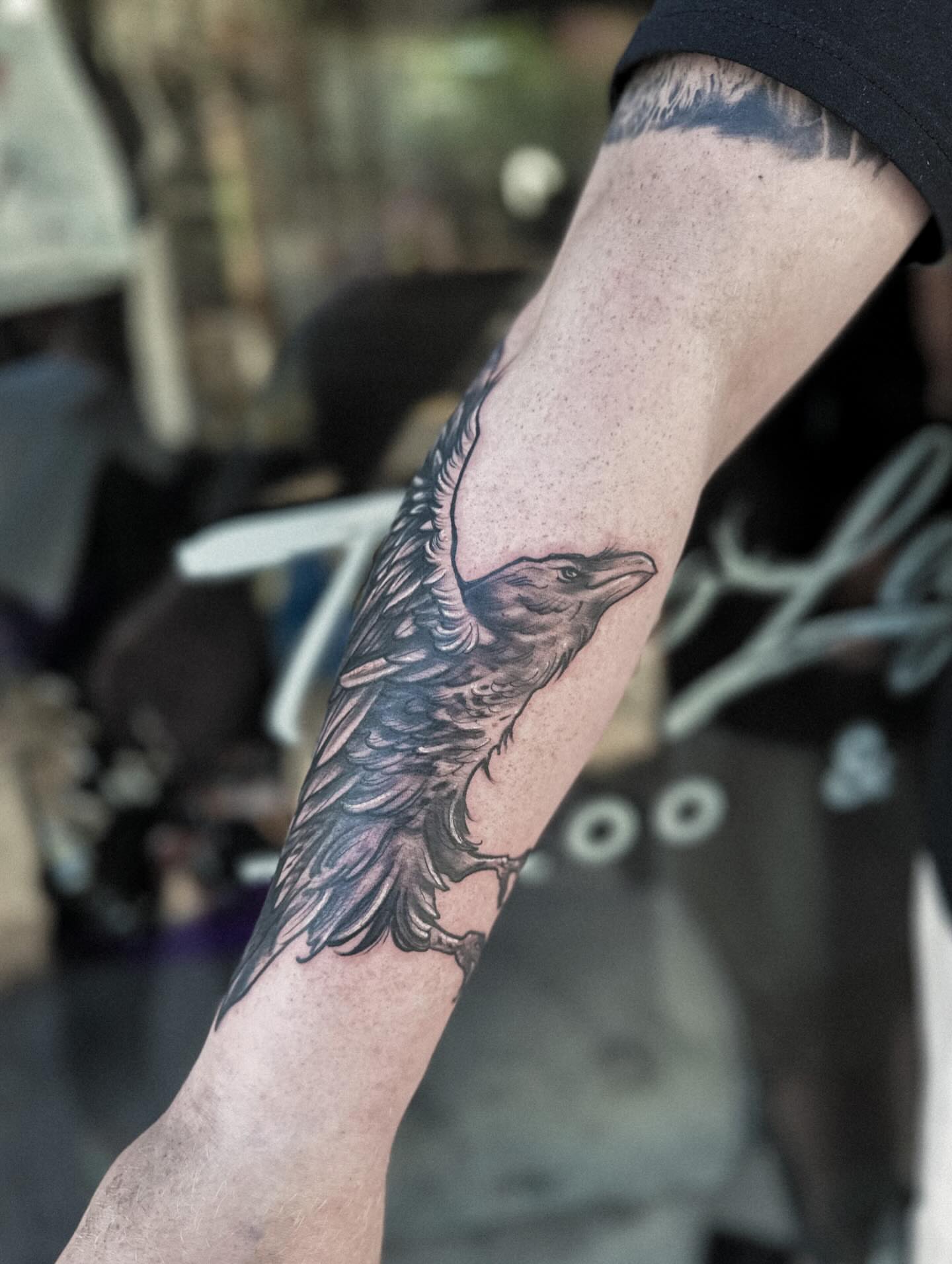 Crow black and grey tattoo on the forearm by Elvira Savchuk