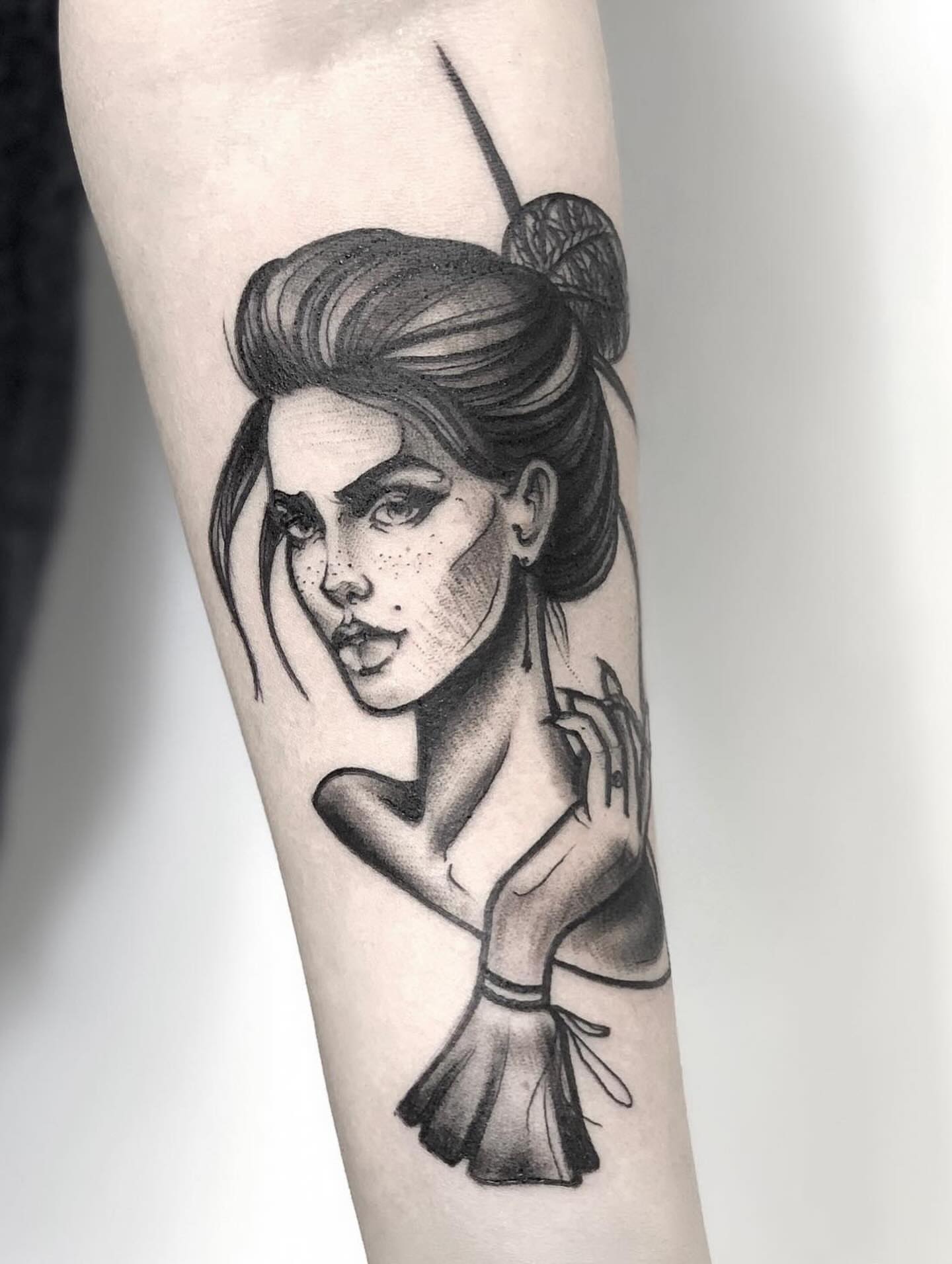 Woman with bun black and grey tattoo on the forearm by Elvira Savchuk
