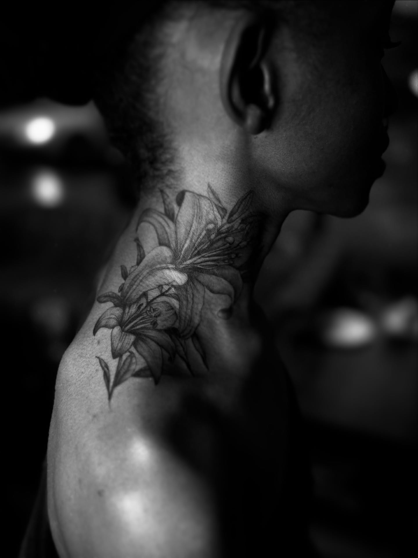 Lily black and grey tattoo on the neck by Gianna G