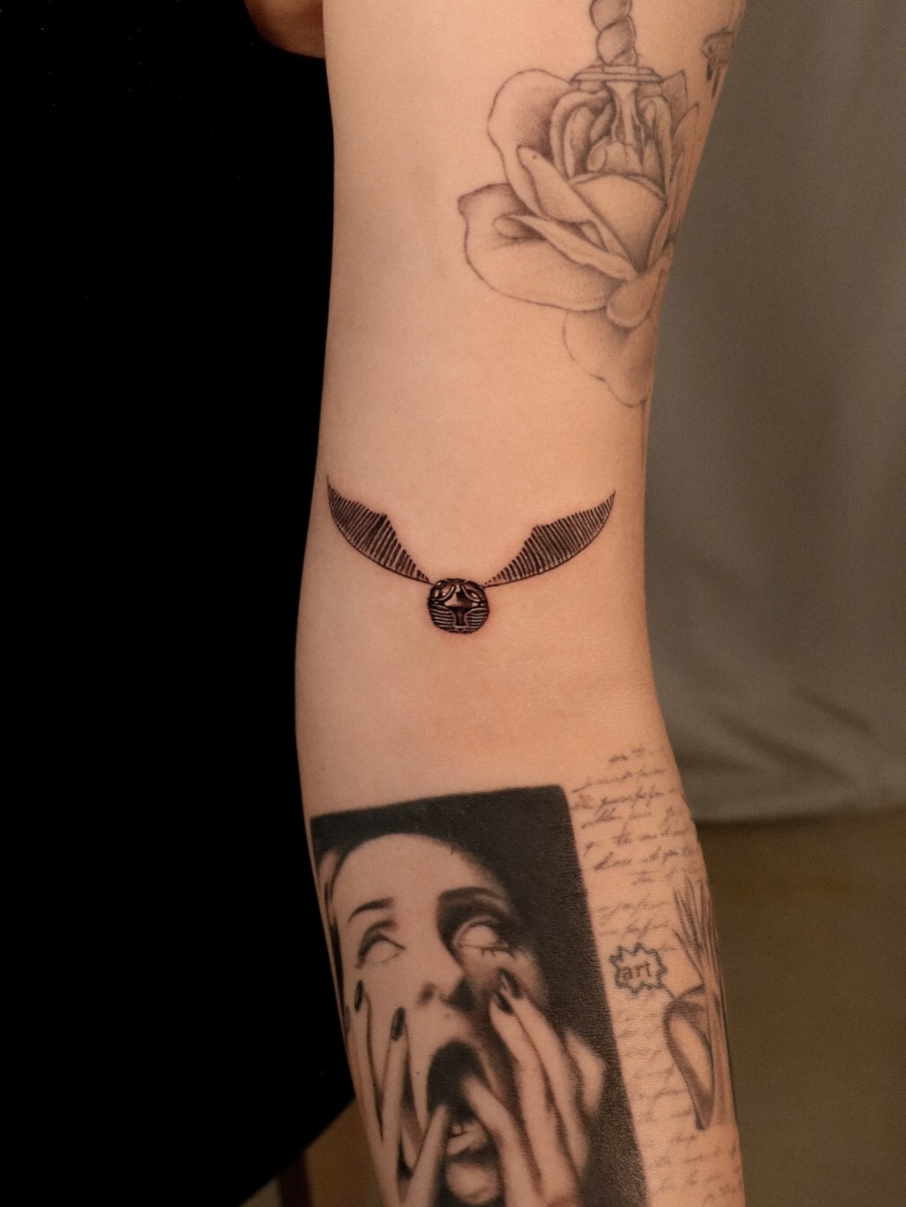 Golden snitch black and grey tattoo on the forearm by Joy Christiana