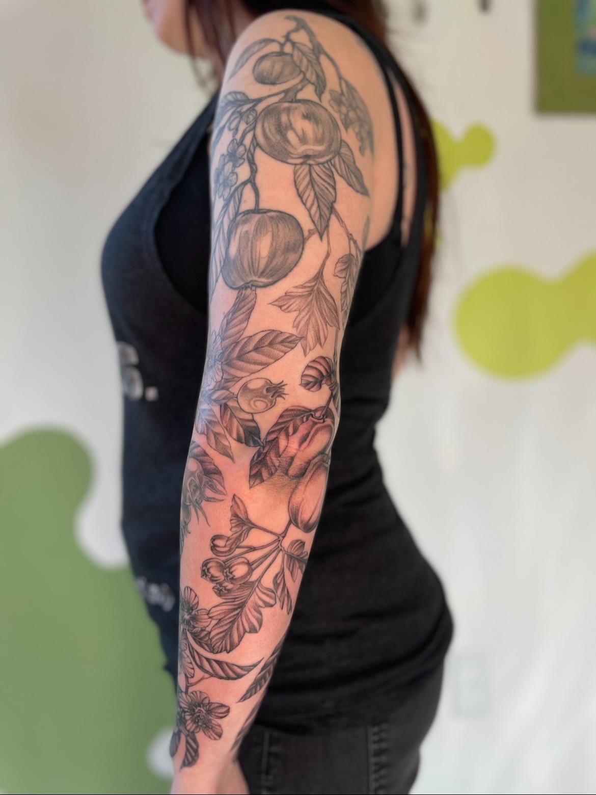 Fruit and floral black and grey tattoo on the upper arm by Eryn, Portland, Oregon