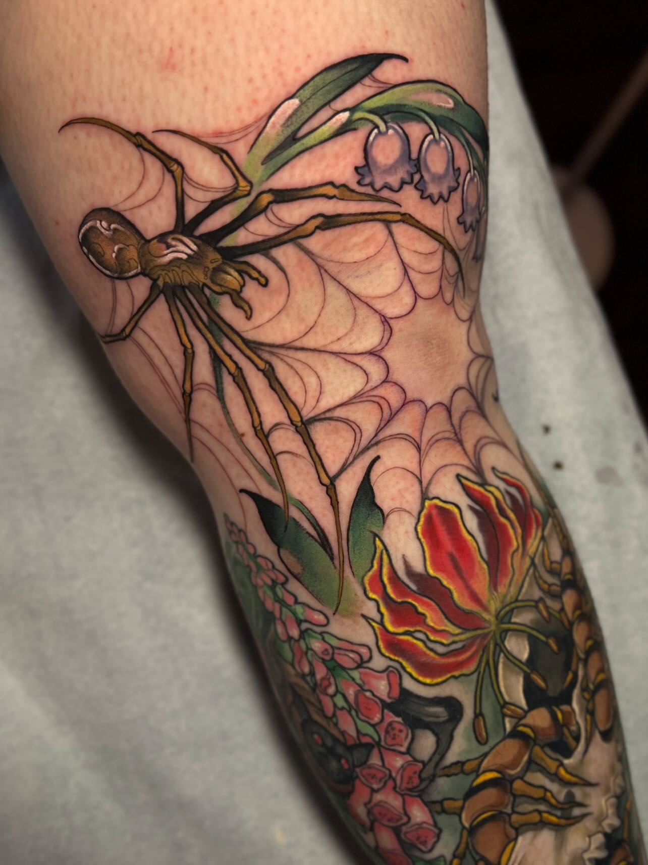 Spider and flowers American traditional tattoo on the forearm by Jen Love