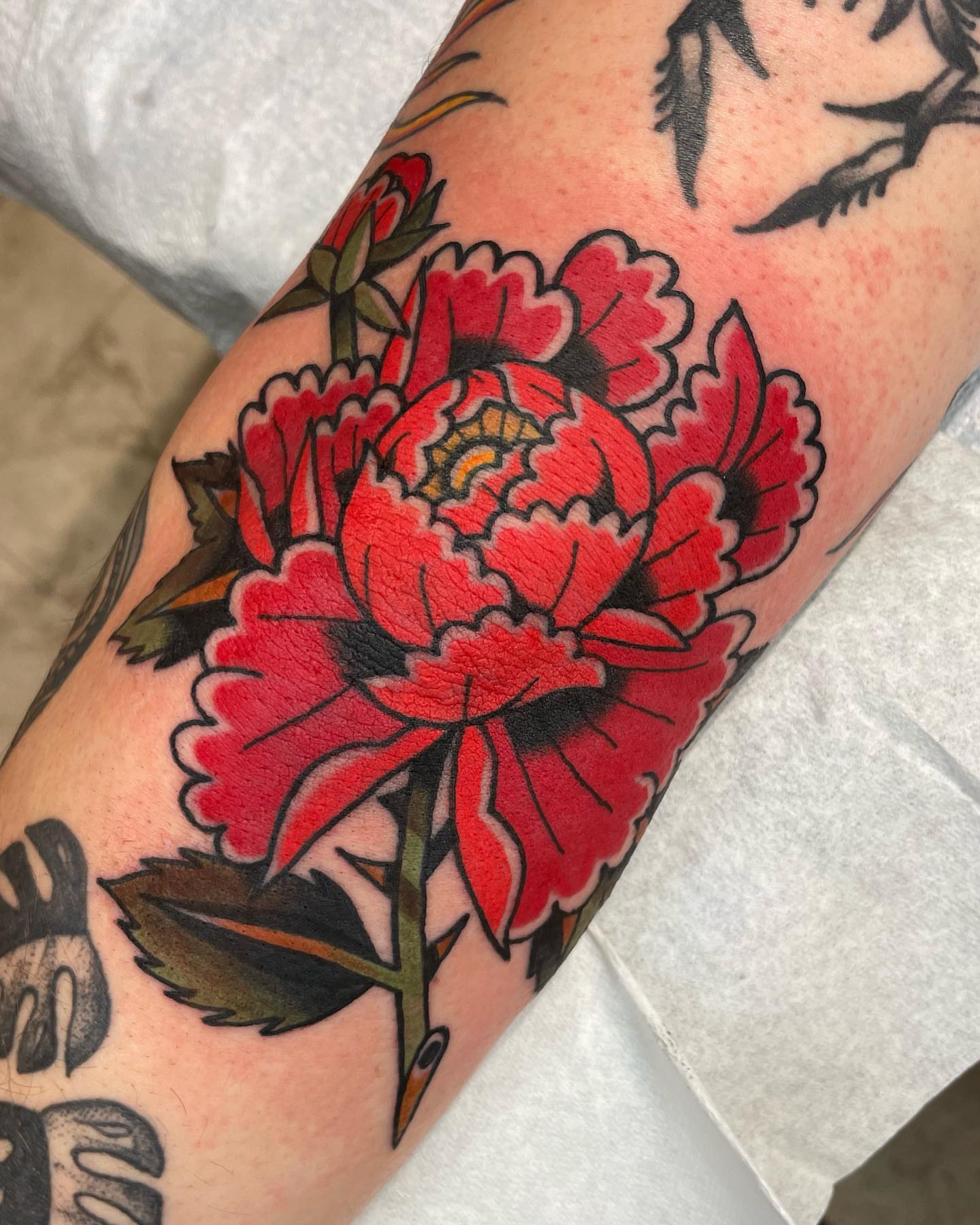 Peony American traditional tattoo on the forearm by Gerald Bellmore