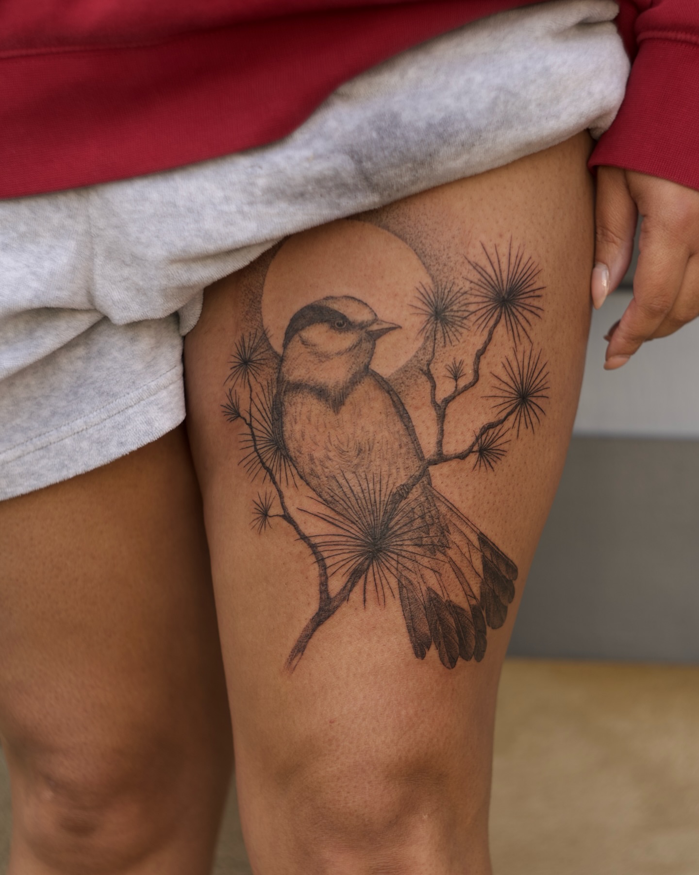 Bird and pine branches black and grey tattoo on the thigh by Kevin Rotramel, Dayton, Ohio