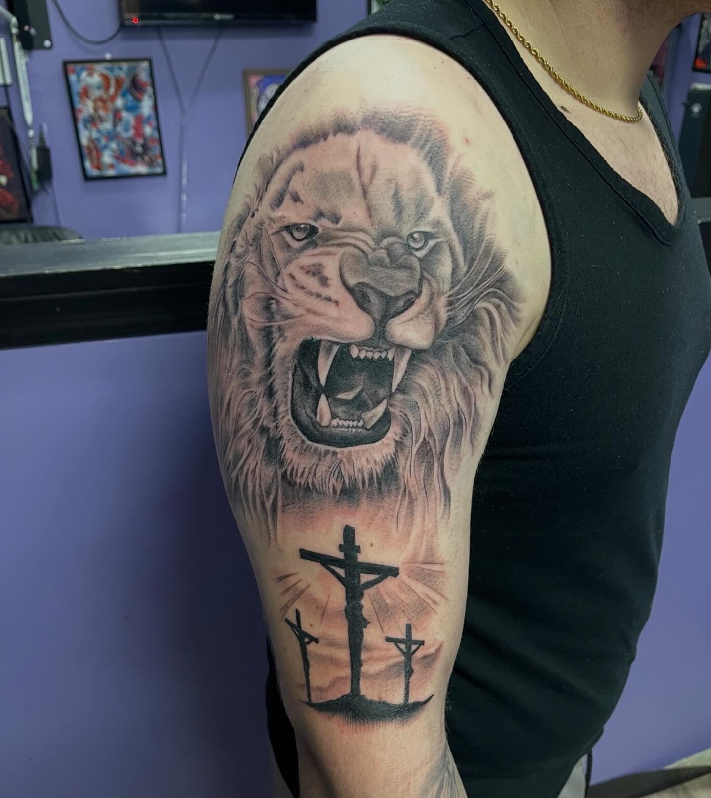 Lion and crucifixion realism tattoo on the forearm by Mark Calloway