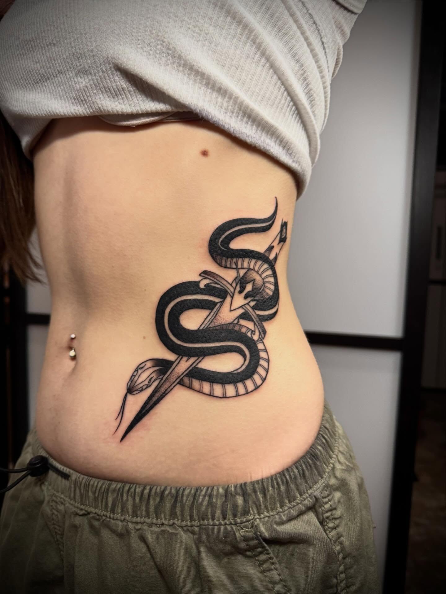 Snake and dagger black and grey tattoo on the ribs by Paul Giovis