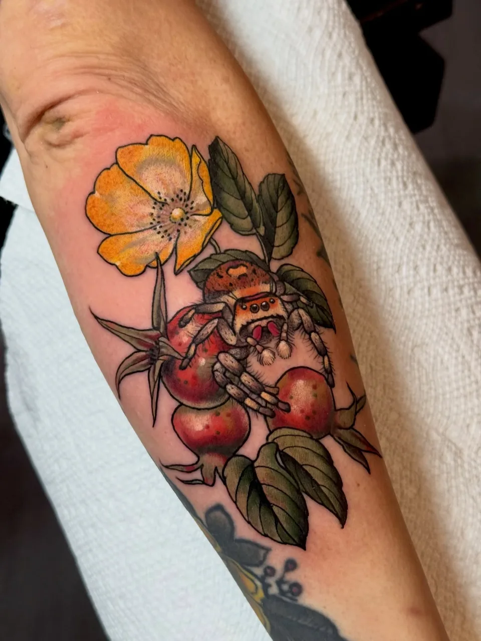 Spider and flowers realism tattoo on the forearm by Lauren Vandevier