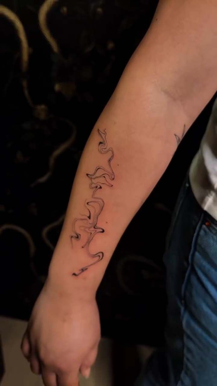 Abstract flowing lines blackwork tattoo on the forearm by Fineline Tattoos π€ Hailey L.