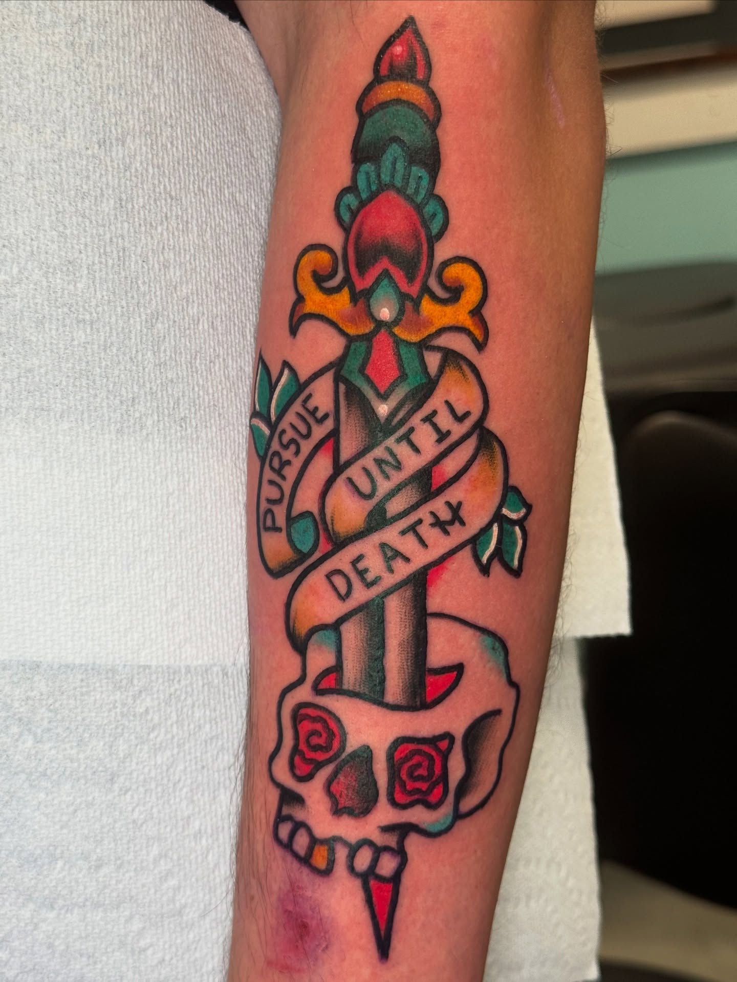 Skull and dagger American traditional tattoo on the forearm by Kenneth Gibson