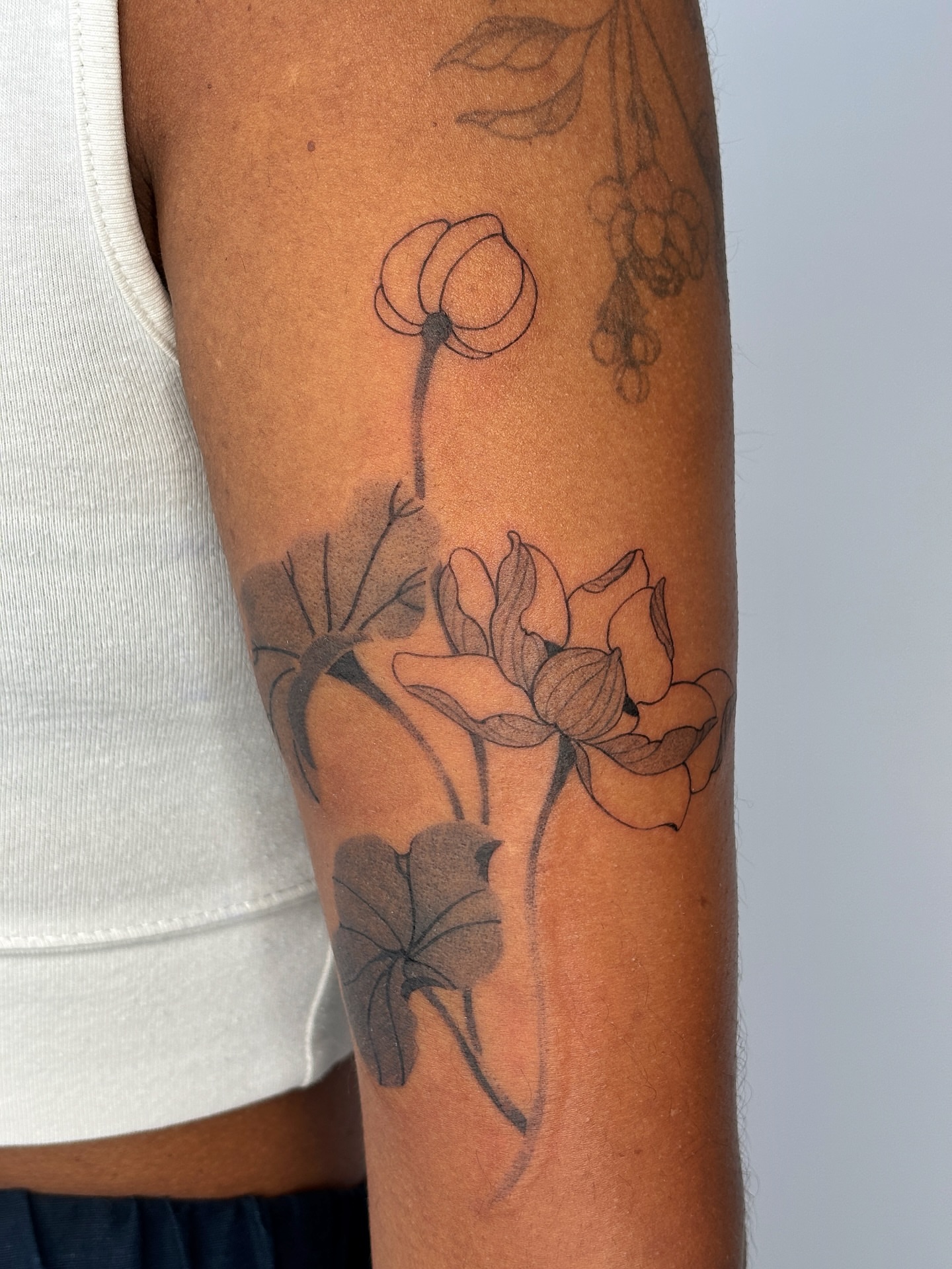 Lotus flowers black and grey tattoo on the forearm by sago, Berkeley, California