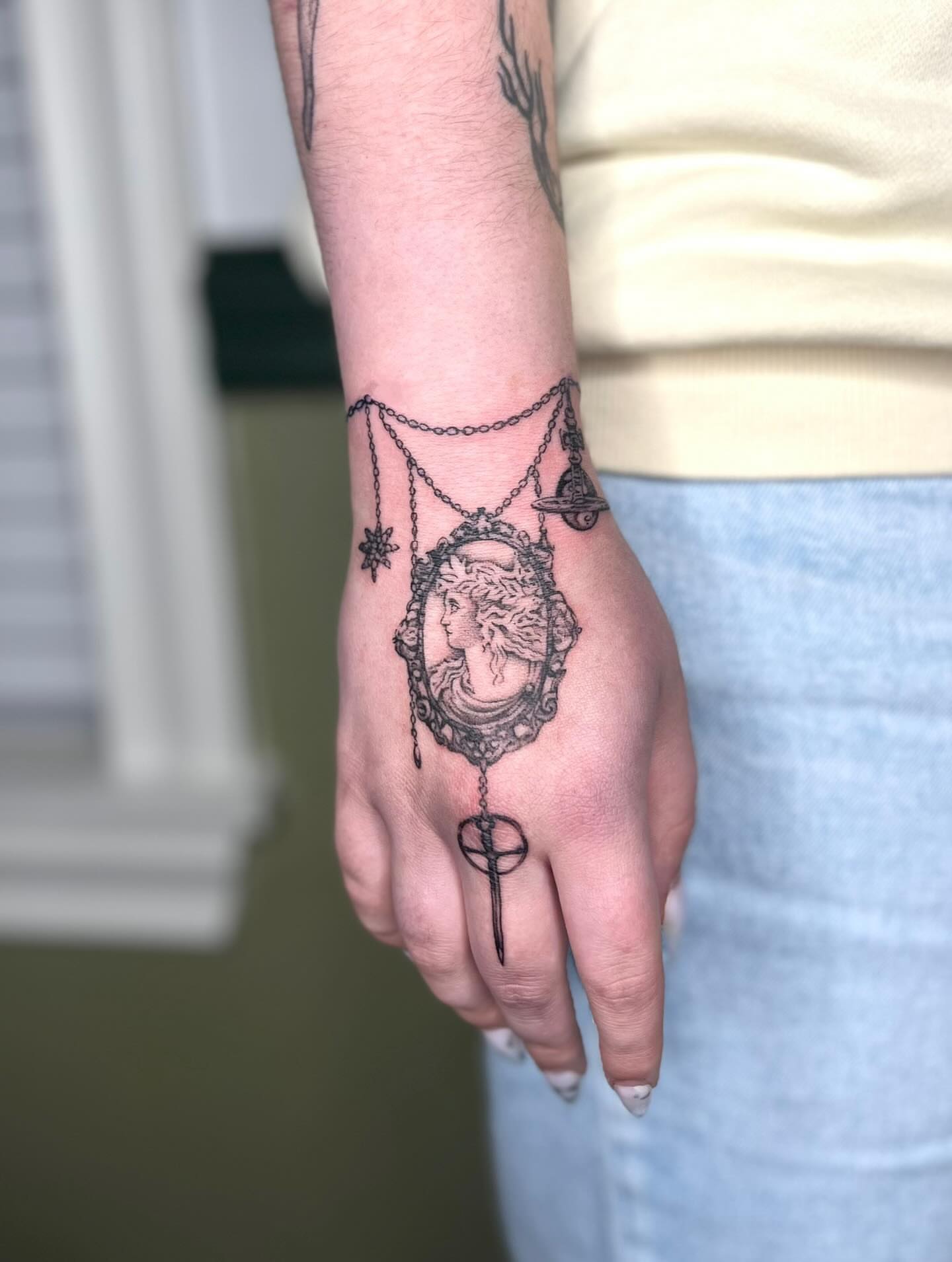 Cameo portrait black and grey tattoo on the hand by Ash F