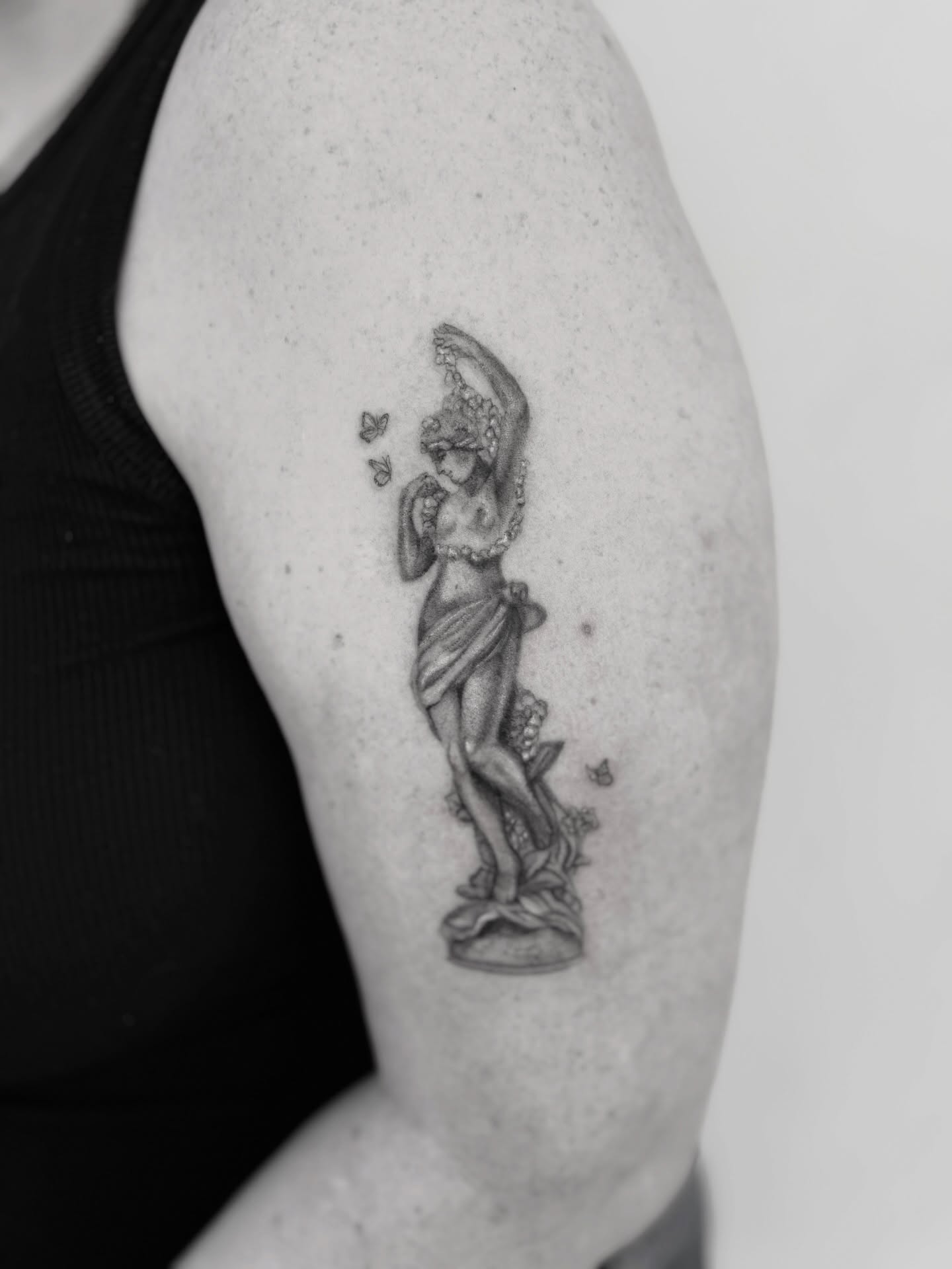 Statue of a woman black and grey tattoo on the upper arm by Raleigh tattoo artist, Raleigh, North Carolina