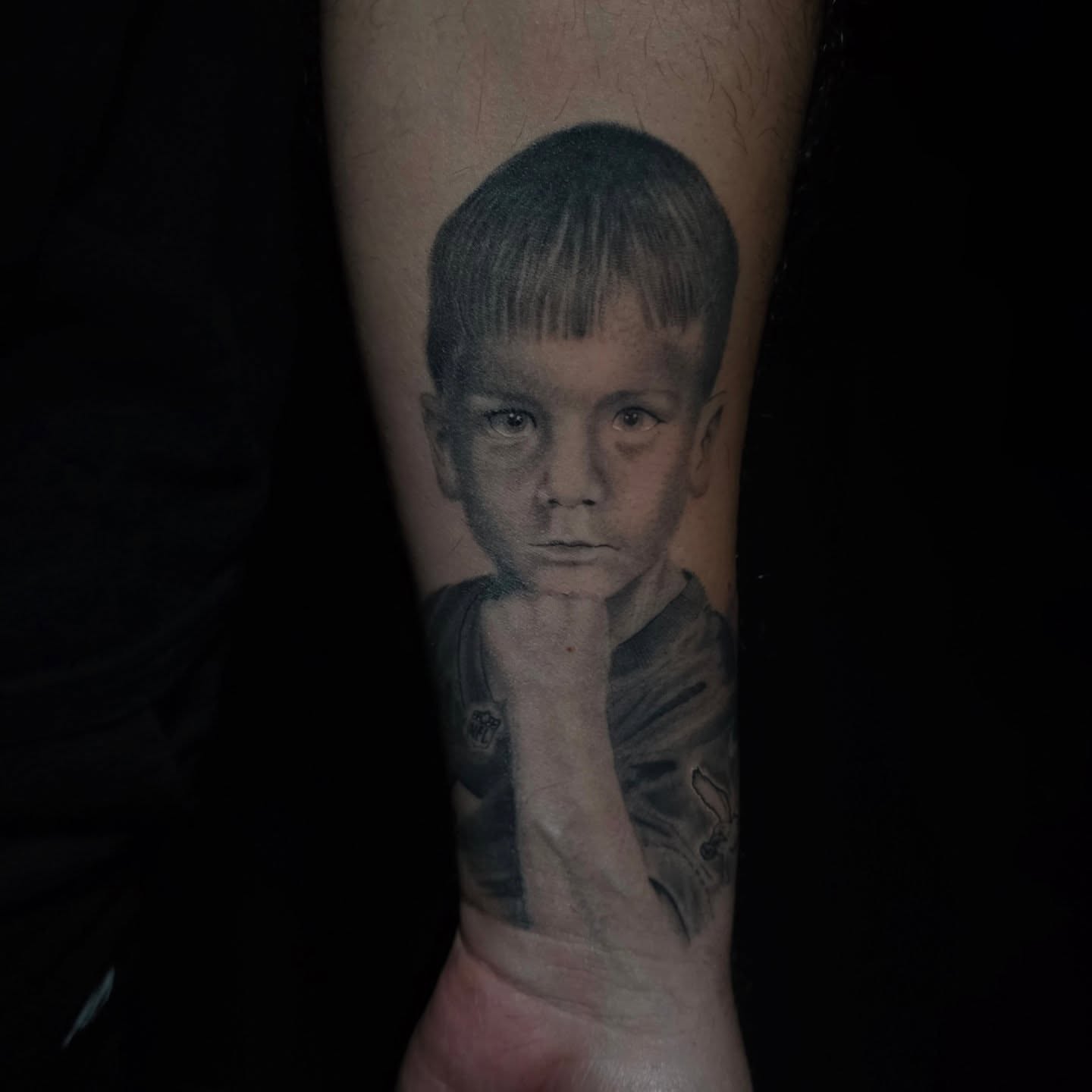Portrait of a boy realism tattoo on the forearm by Anna Brittany