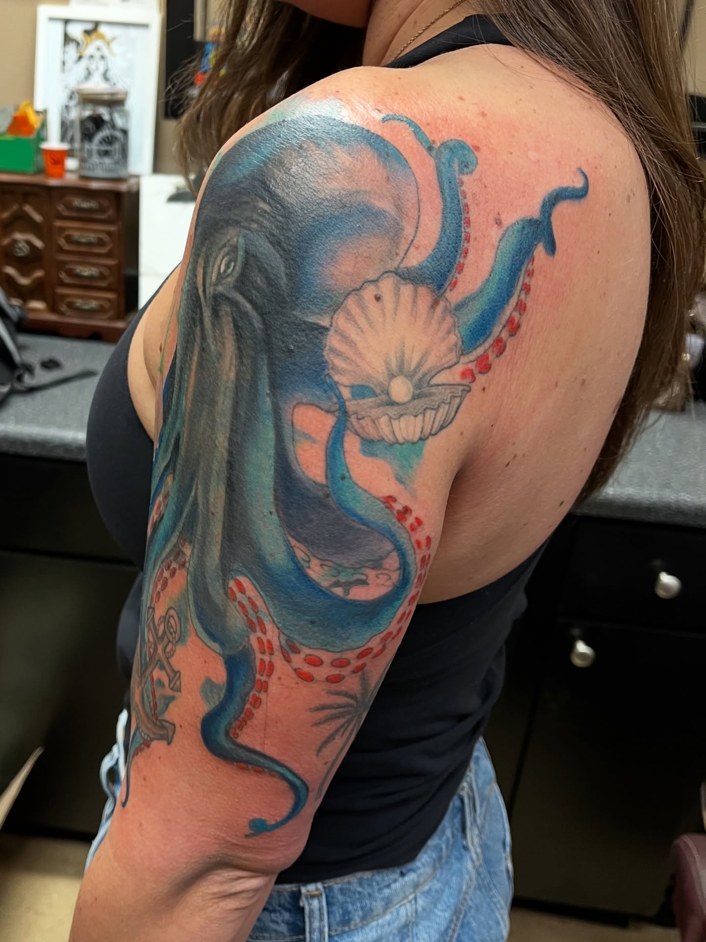 Octopus and shell realism tattoo on the upper arm by Tabitha Mathis
