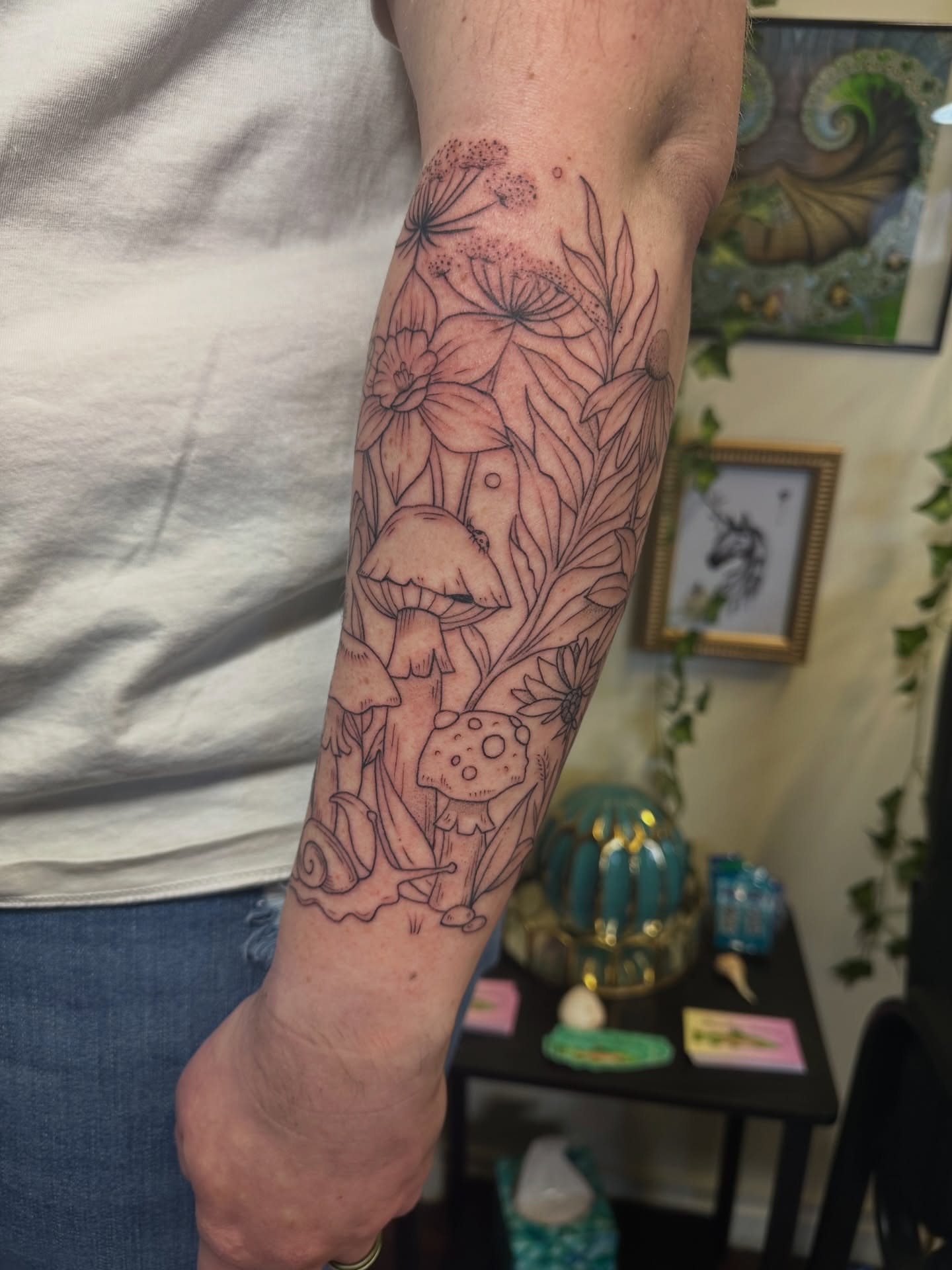 Mushroom and floral bouquet fine line tattoo on the forearm by Lauren